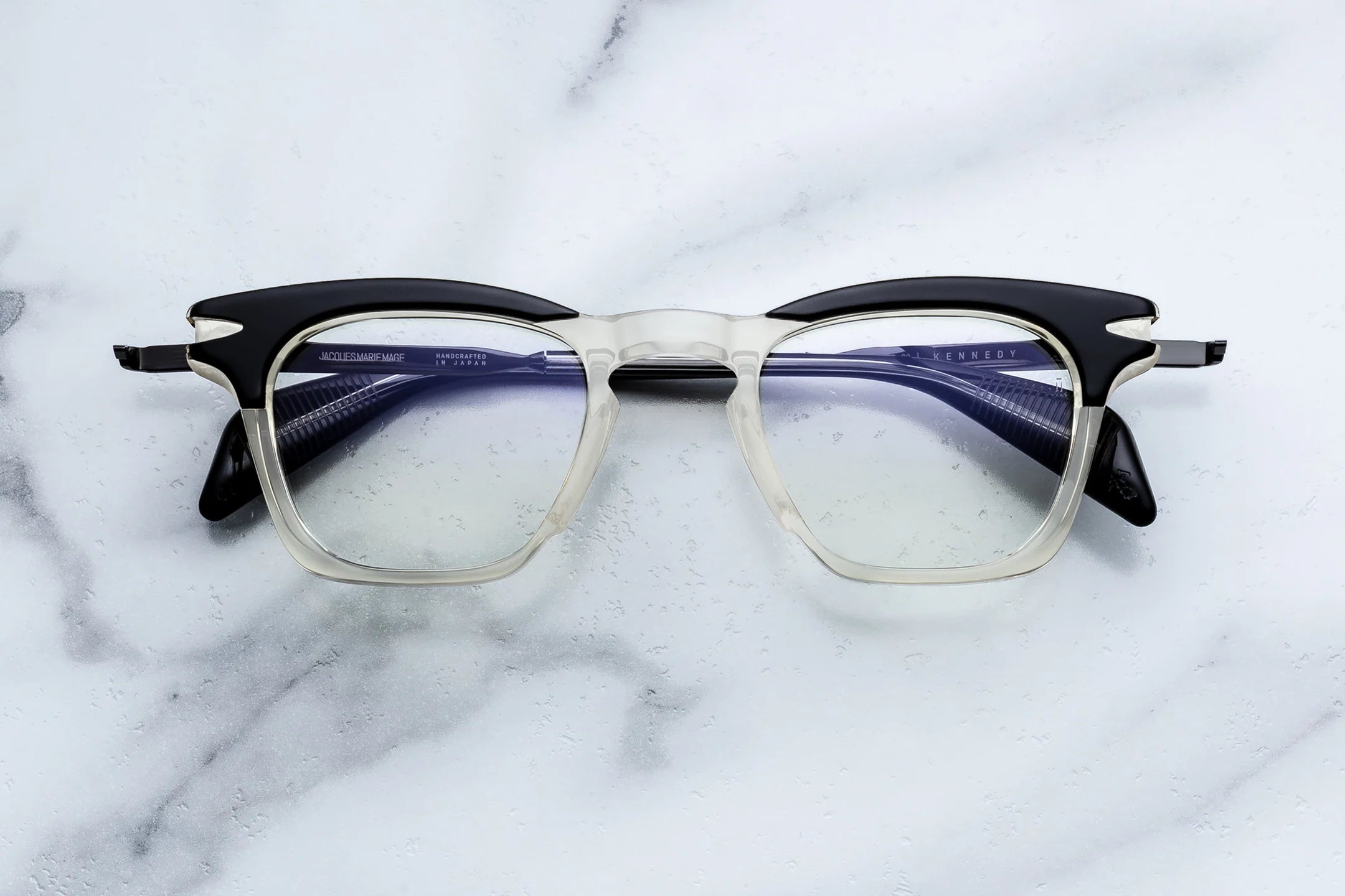 Eyeglasses with black and clear frame on a marble surface