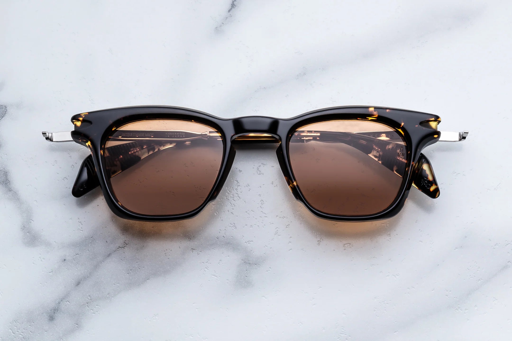 Sunglasses with brown lenses on a marble surface