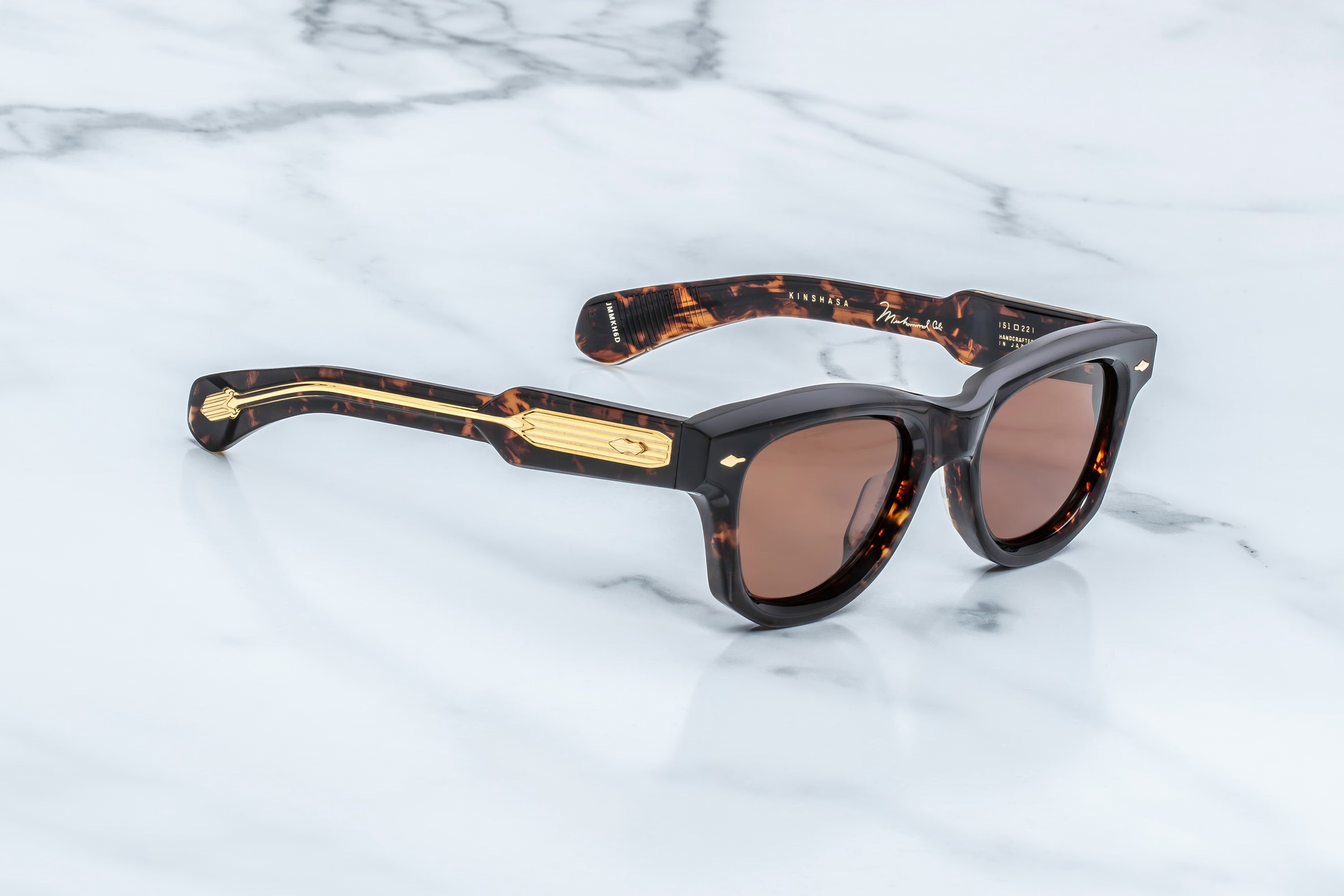 Sunglasses with tortoiseshell frame and brown lenses on a marble surface
