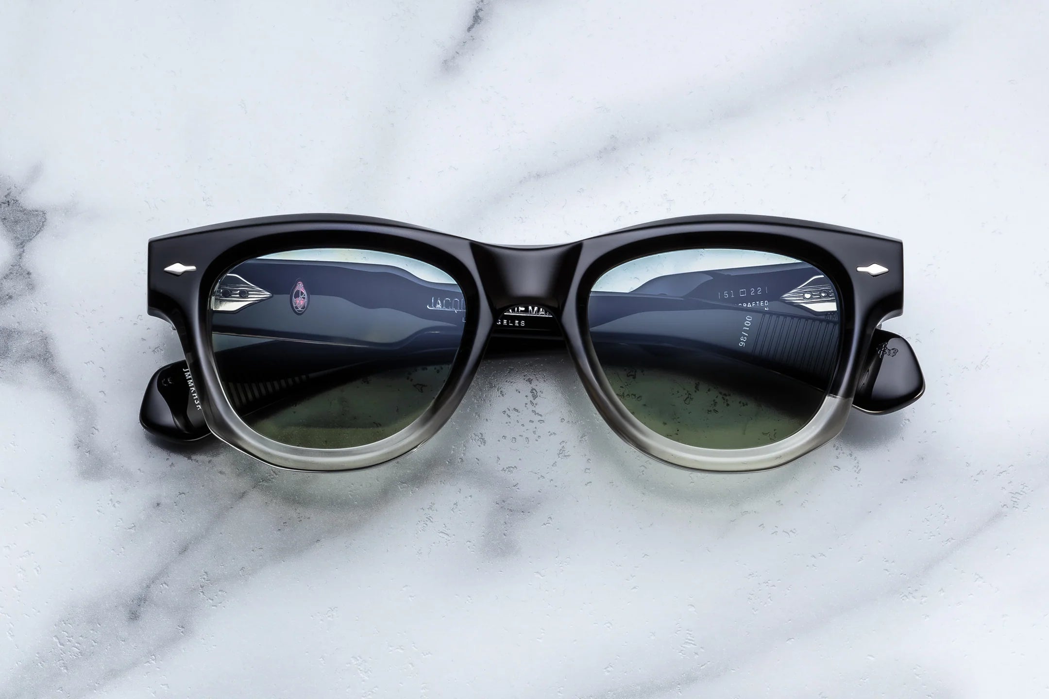 Black sunglasses with reflective lenses on a marble surface