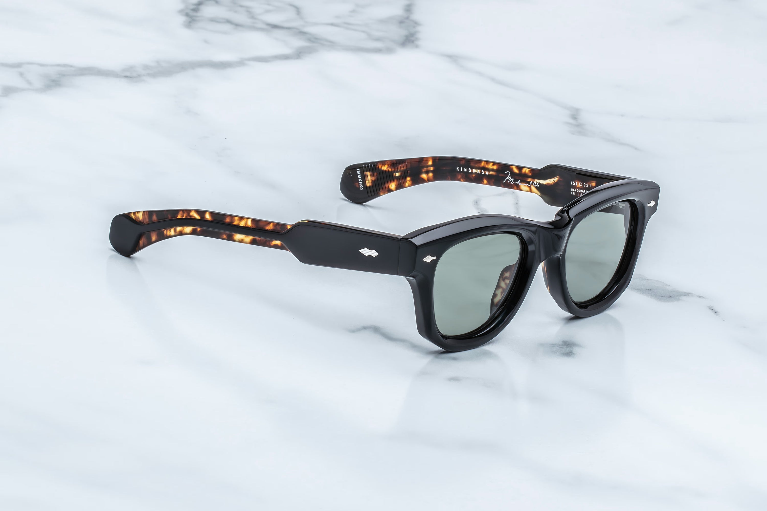 Sunglasses with tortoiseshell arms on a marble surface