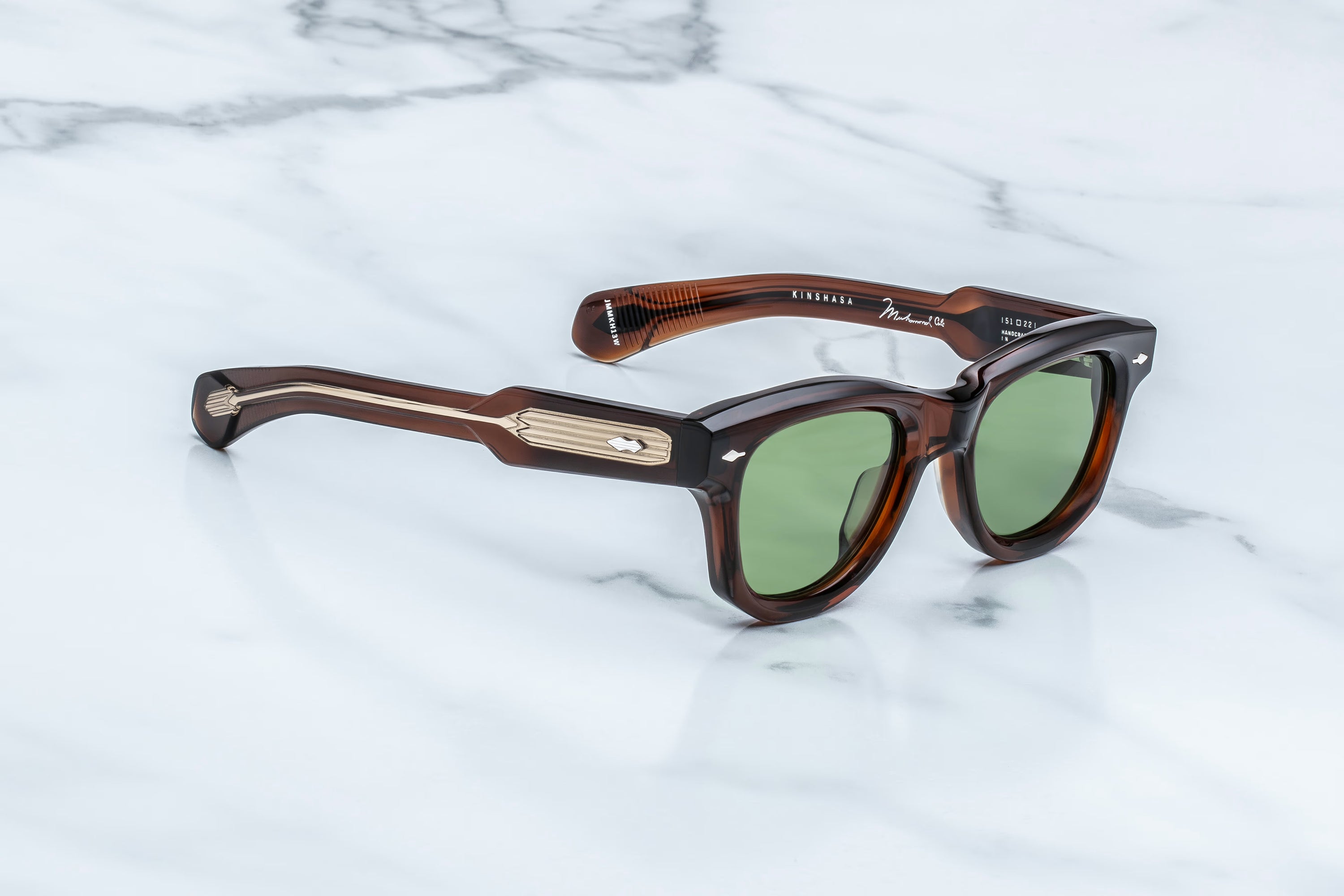 Brown sunglasses with green lenses on a marble surface
