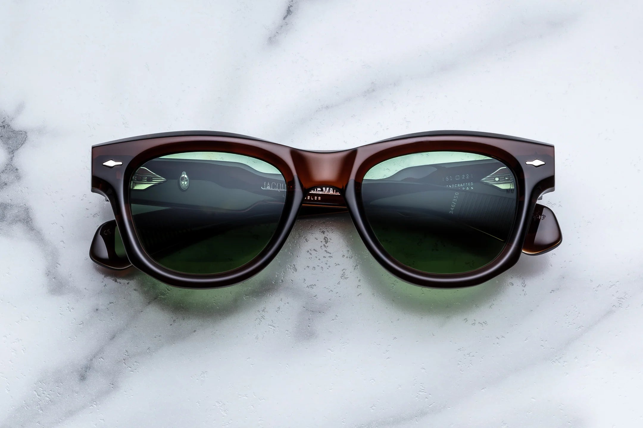 Brown sunglasses with dark lenses on a marble surface
