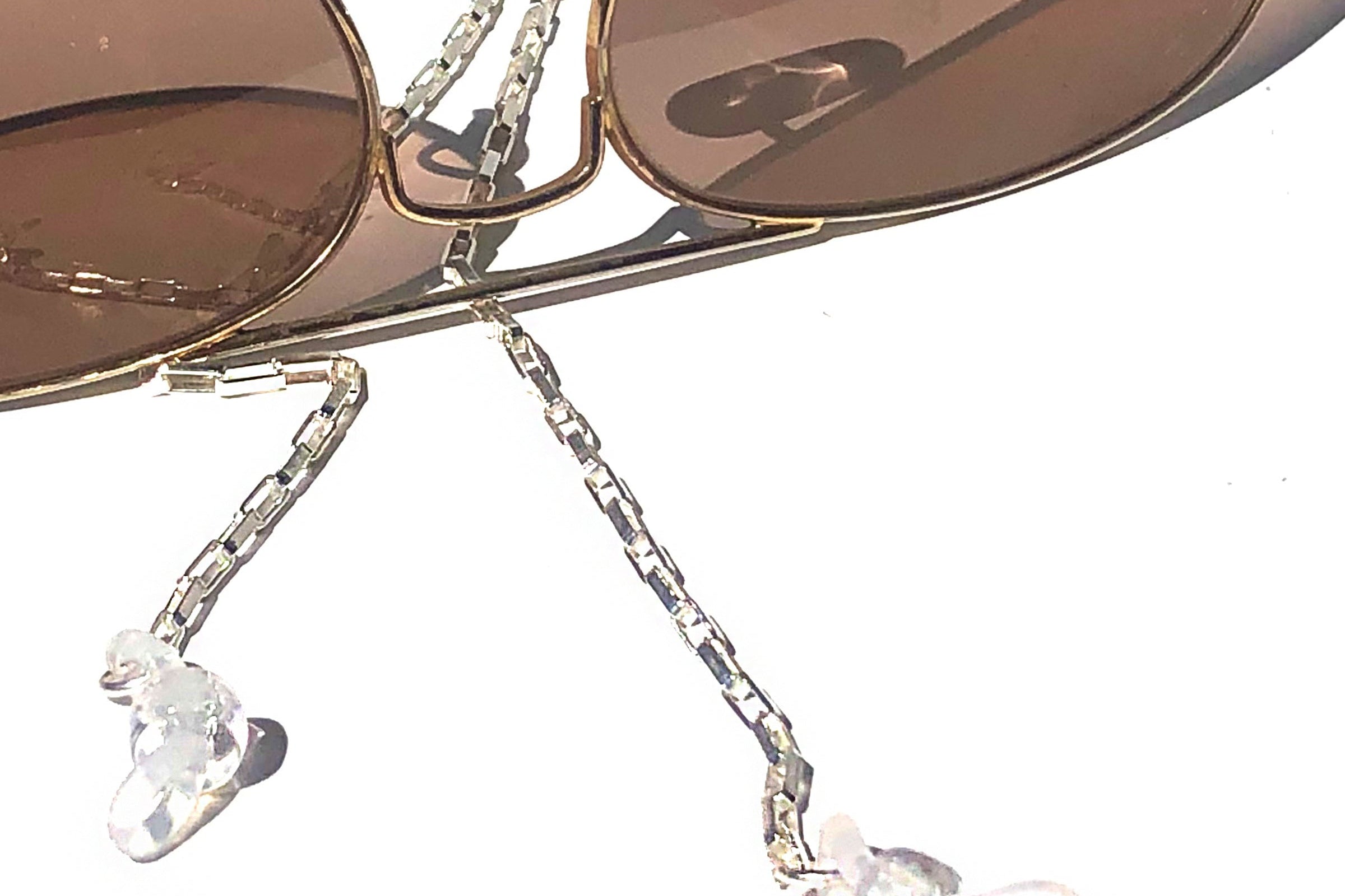 Sunglasses with decorative chain and heart-shaped charms on a white background