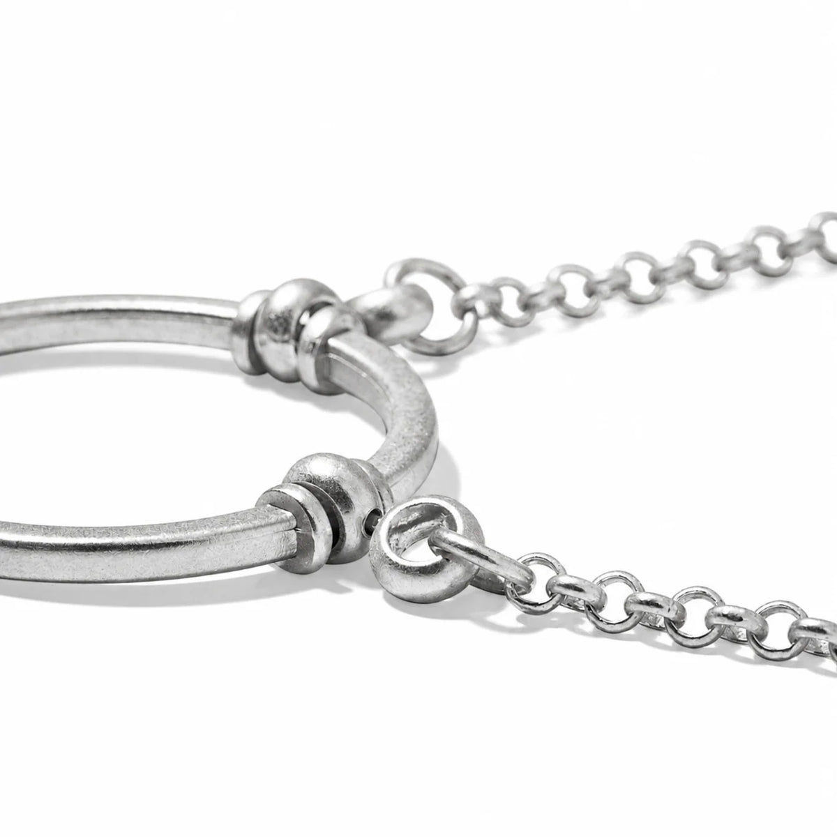 A silver circular La Loop Claudia glasses holder attached to a delicate link chain.