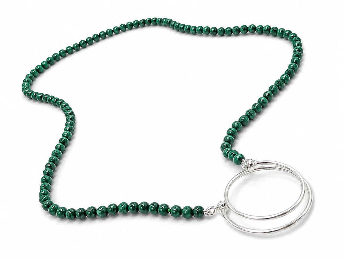 A La Loop Luna necklace featuring green patterned malachite-style beads and two silver-toned interlocking rings at the base.
