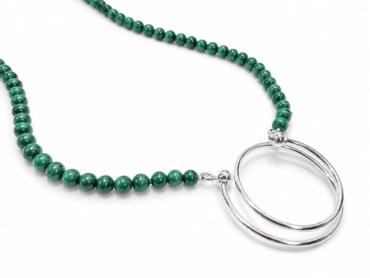 La Loop Luna necklace handcrafted from green banded malachite beads with two silver-plated metal rings attached at the center.