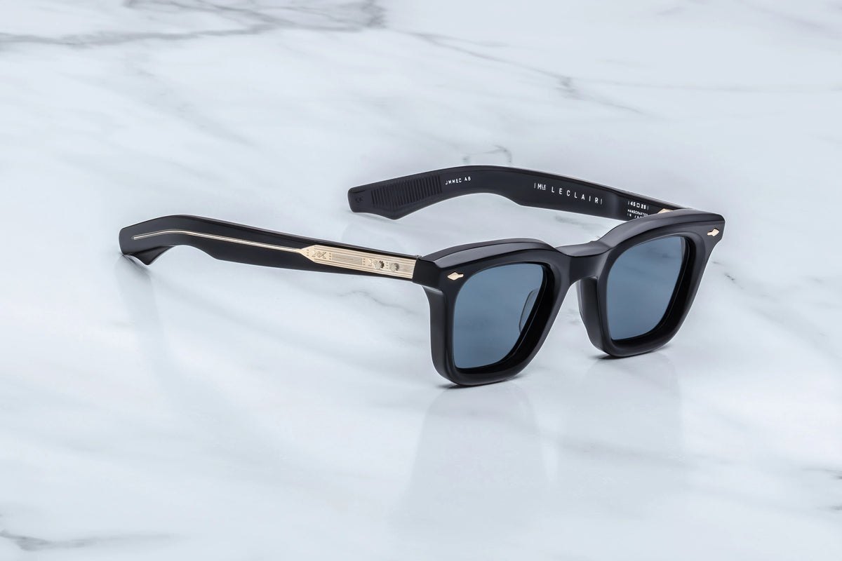 Jacques Marie Mage Leclair sunglasses featuring black rectangular, Wellington-shaped frames, blue lenses, and gold metal detailing on the temples.
