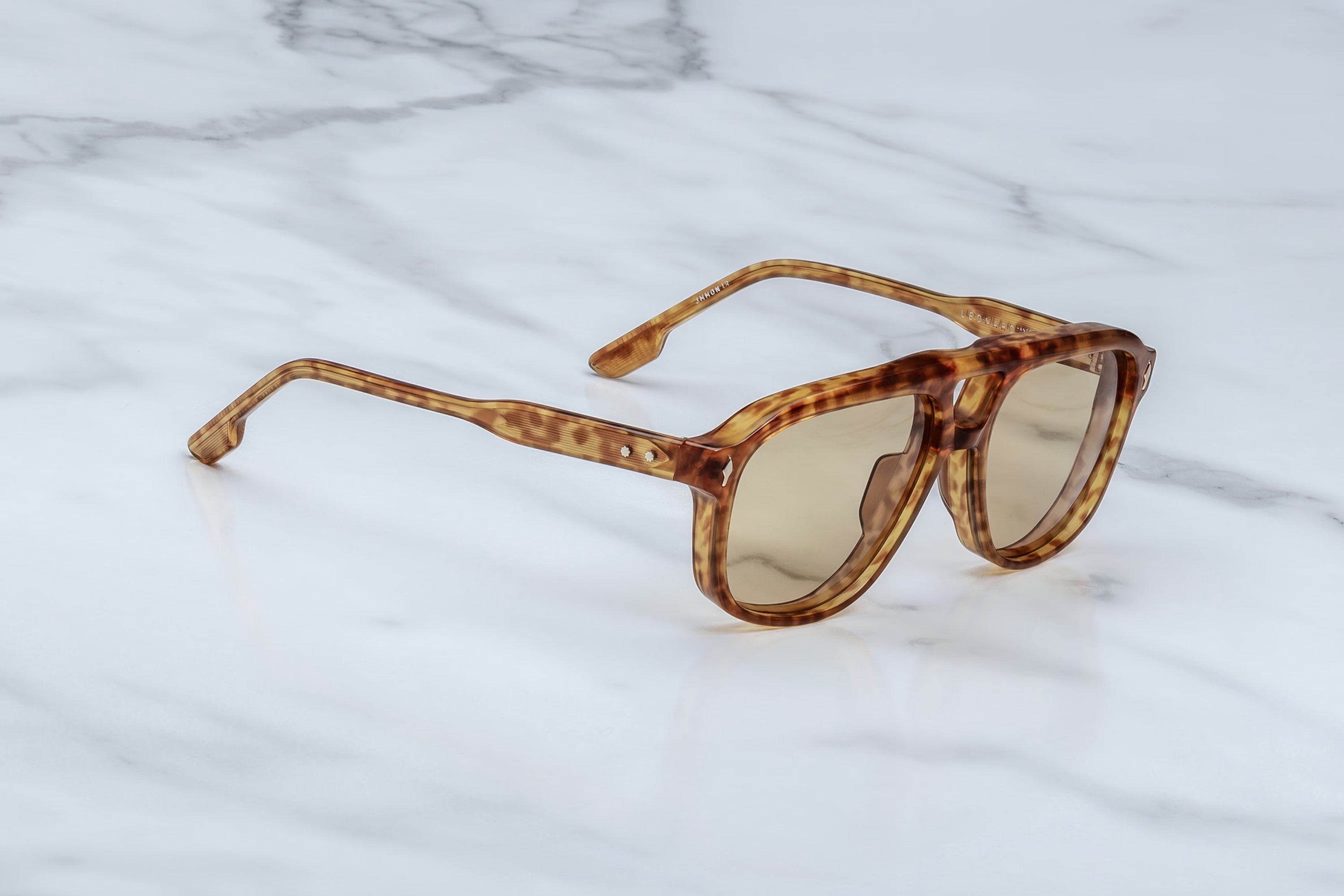 Brown tortoiseshell sunglasses on a marble surface