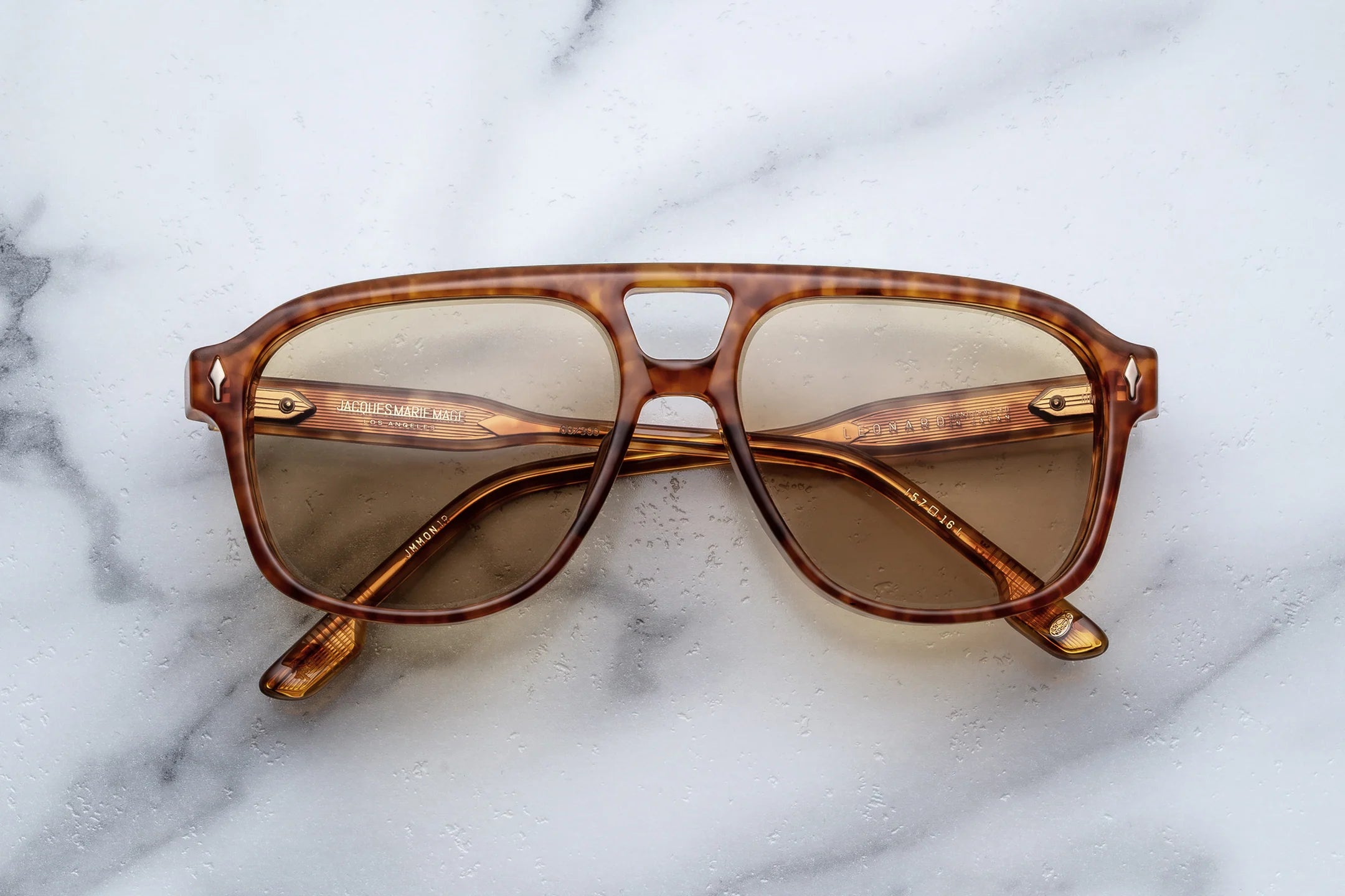Brown sunglasses with tortoiseshell frame on a marble surface