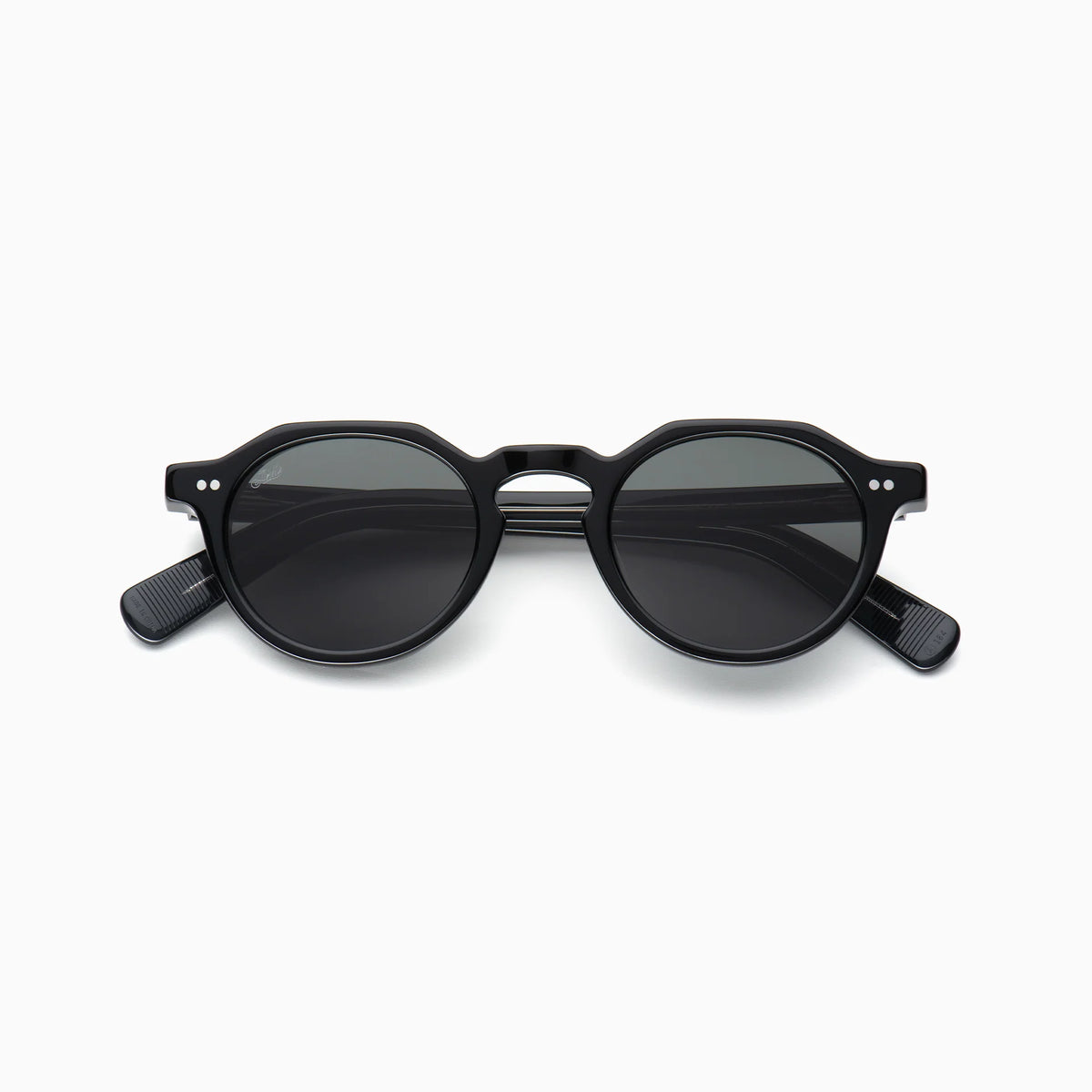 Akila Lola sunglasses by Akila, shown from the front against a white background. These black round sunglasses feature dark lenses, a contemporary frame design, a keyhole bridge, and thick paddle-shaped temples for a bold statement look.
