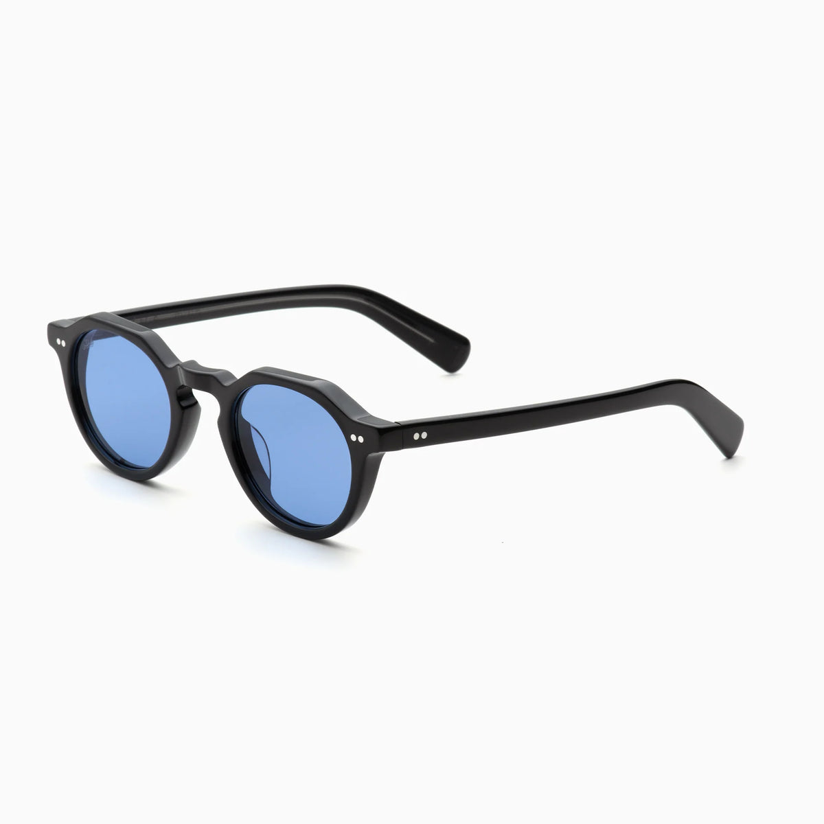 The Akila Lola sunglasses by Akila feature black frames with round, blue-tinted lenses and two small silver dots on each temple. These contemporary eyeglass frames have paddle-shaped temples and are displayed on a plain white background.