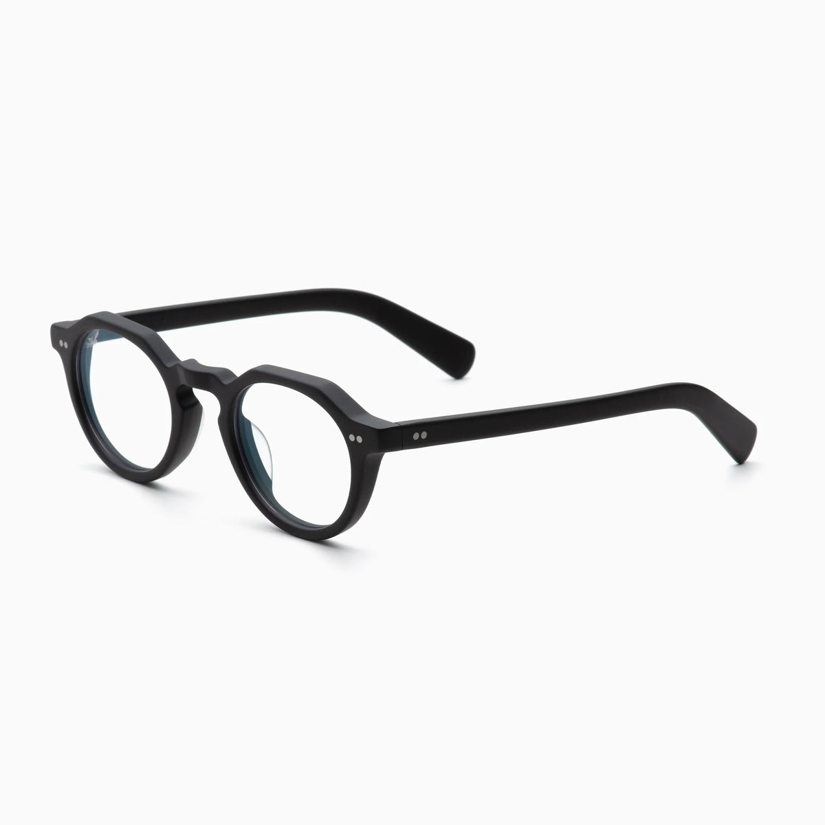 Akila Lola eyeglasses by Akila feature round black frames with a bold, thick design and clear lenses, displayed on a white background at an angle. These contemporary frames effortlessly blend classic style with modern accents, making them a standout choice for any look.