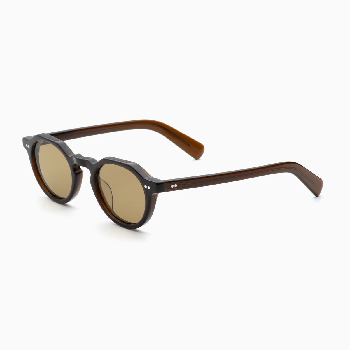 The Akila Lola by Akila features brown round sunglasses with paddle-shaped temples and light brown lenses in a contemporary frame design. The narrow-fit glasses are shown on a white background at a slight angle.