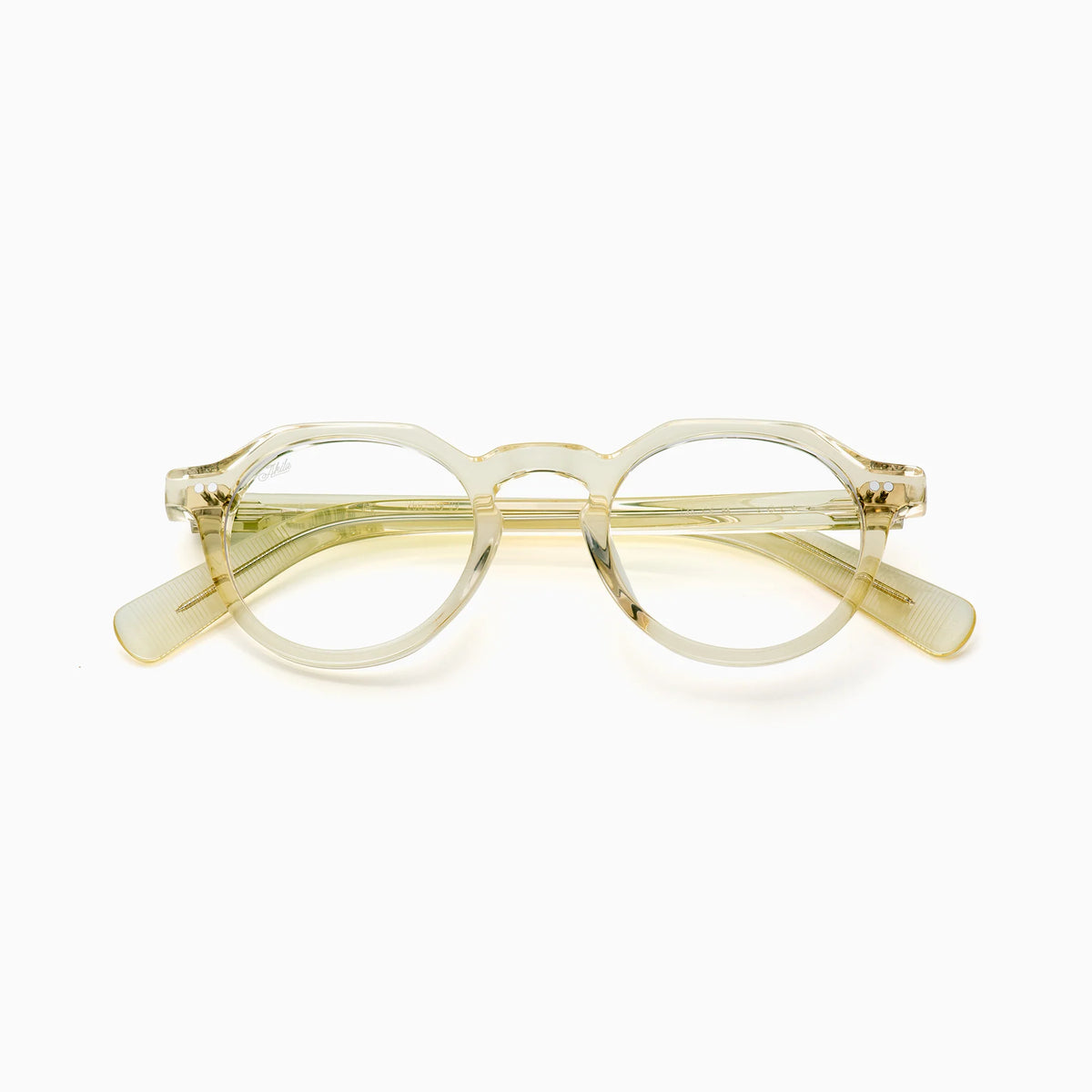 The Akila Lola eyeglasses by Akila feature clear round optical frames with a subtle light yellowish tint, displayed against a plain white background. These contemporary glasses showcase translucent frames, complemented by temples that slightly widen at the ends for enhanced comfort.