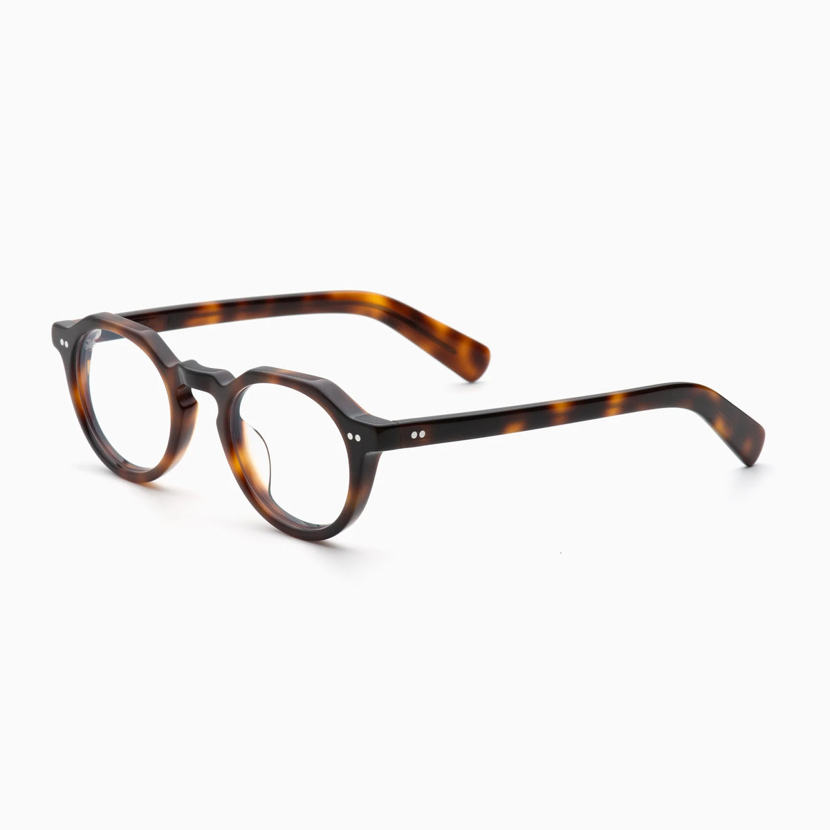Akila Lola optical frames by Akila feature a thick, round tortoiseshell construction with two small silver dots on each side, shown against a white background. These contemporary eyeglasses blend classic elegance with modern style.