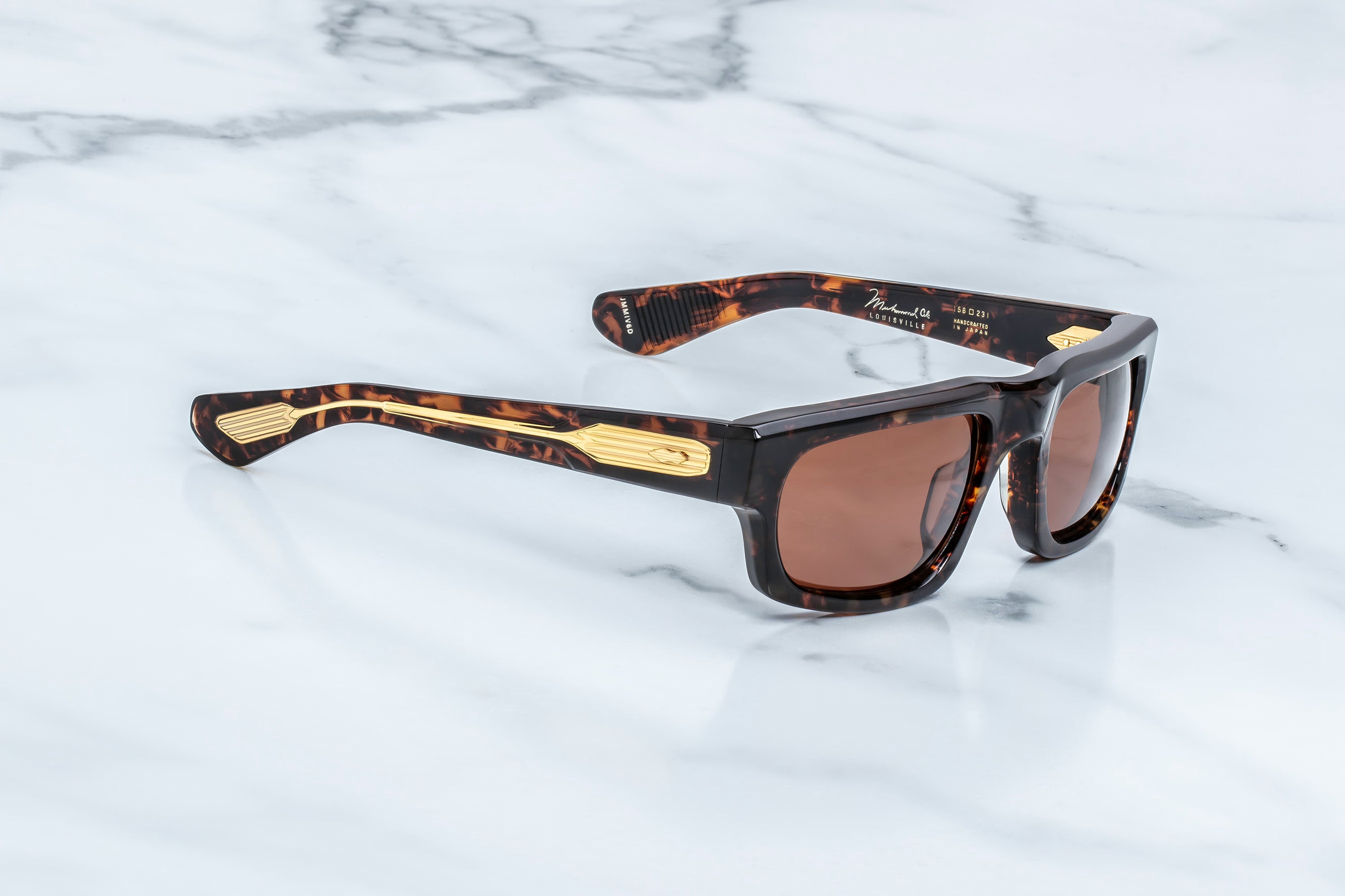 Sunglasses with tortoiseshell frame and brown lenses on a marble background