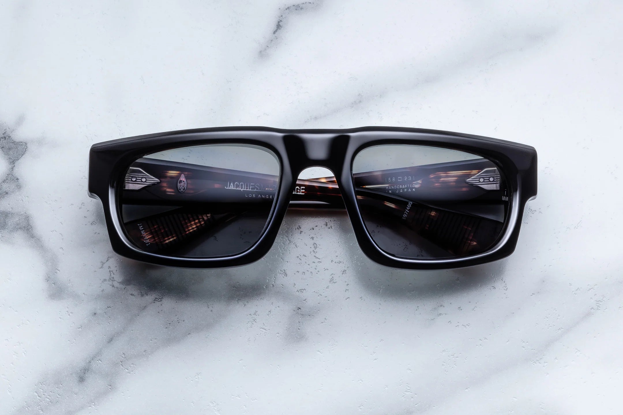 Black sunglasses on a white marble surface