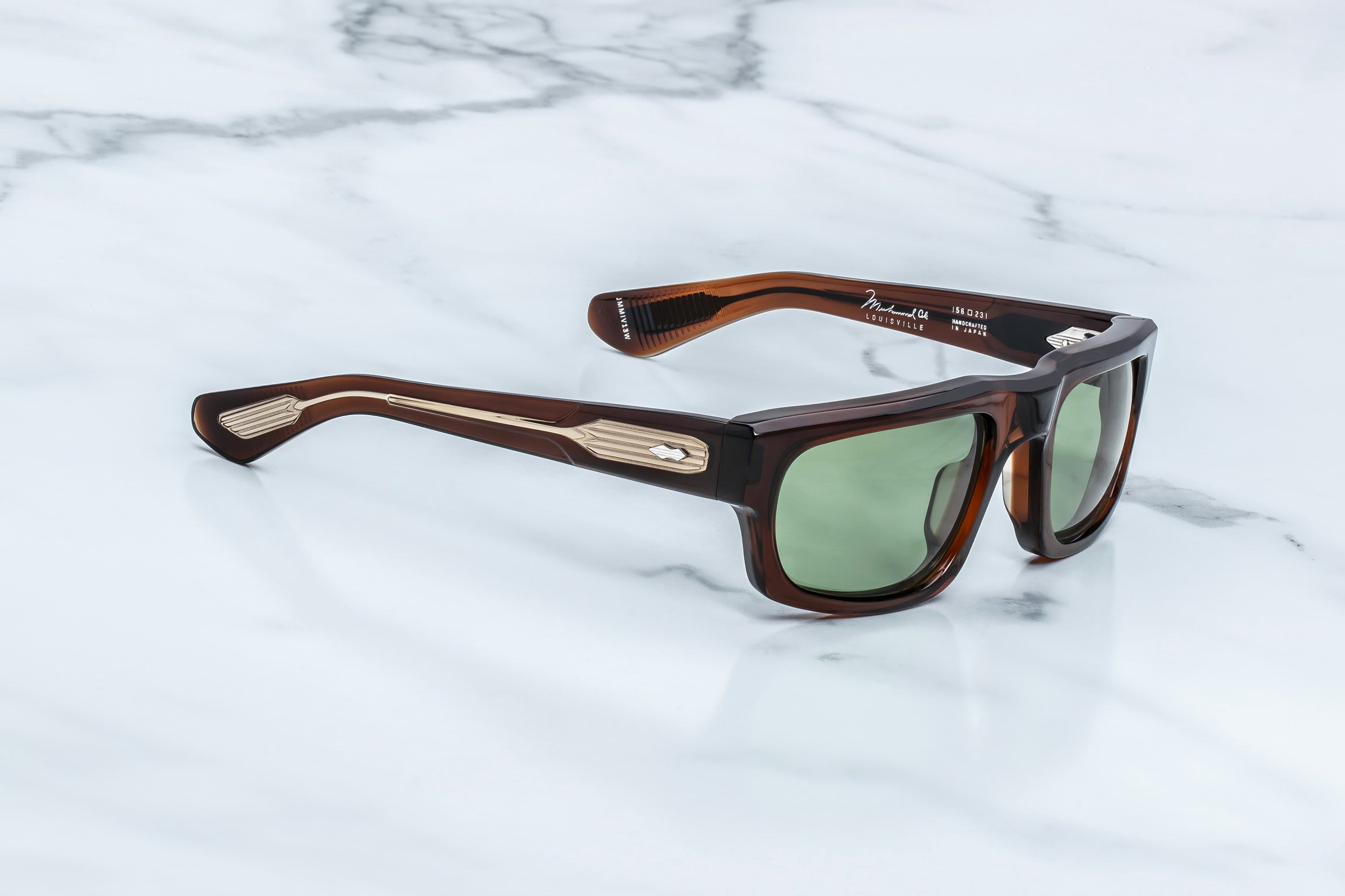 Brown sunglasses with green lenses on a marble surface