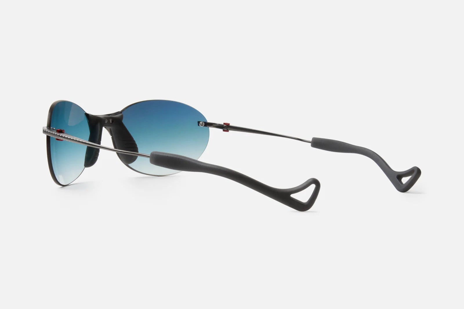 District Vision Mami Vantage Ti by District Vision: Rimless sunglasses with blue gradient lenses and slim black frames, crafted with curved, flexible black titanium temples for a customizable fit, shown against a plain white background.