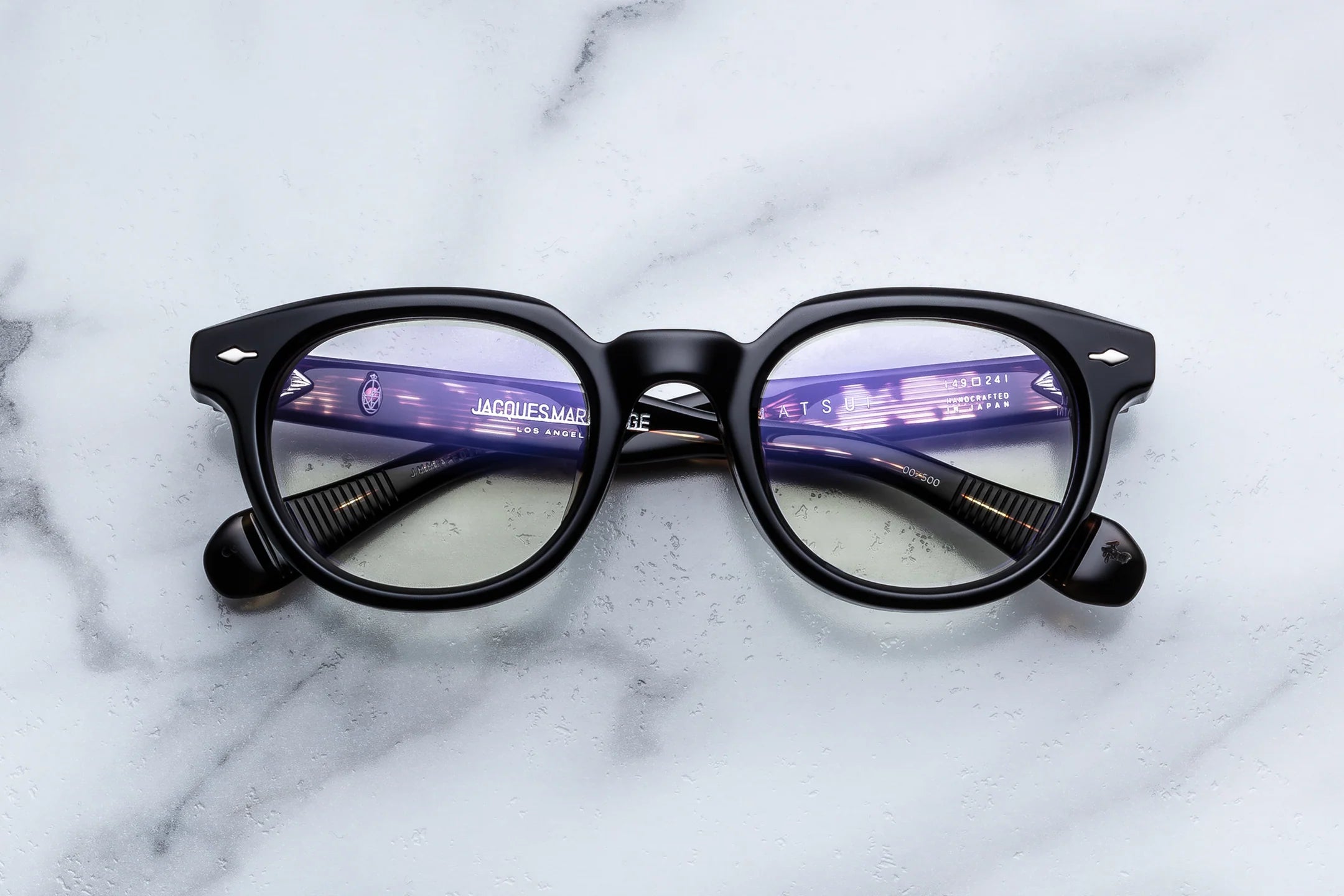 Black-framed eyeglasses on a marble surface