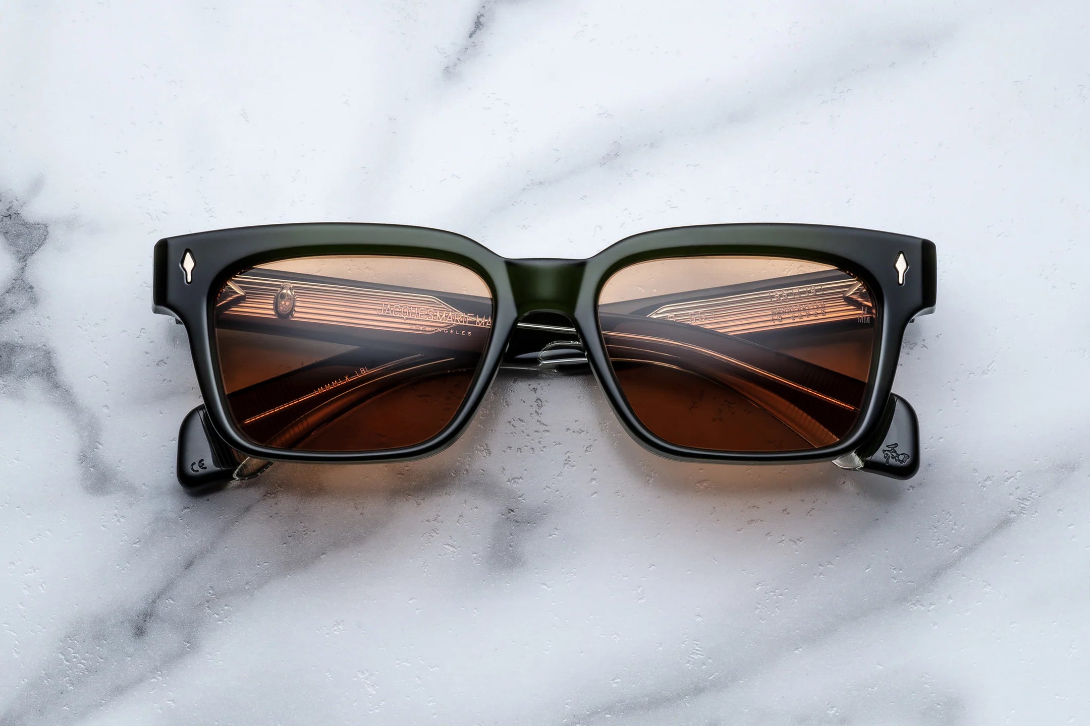 Sunglasses with brown lenses on a marble surface