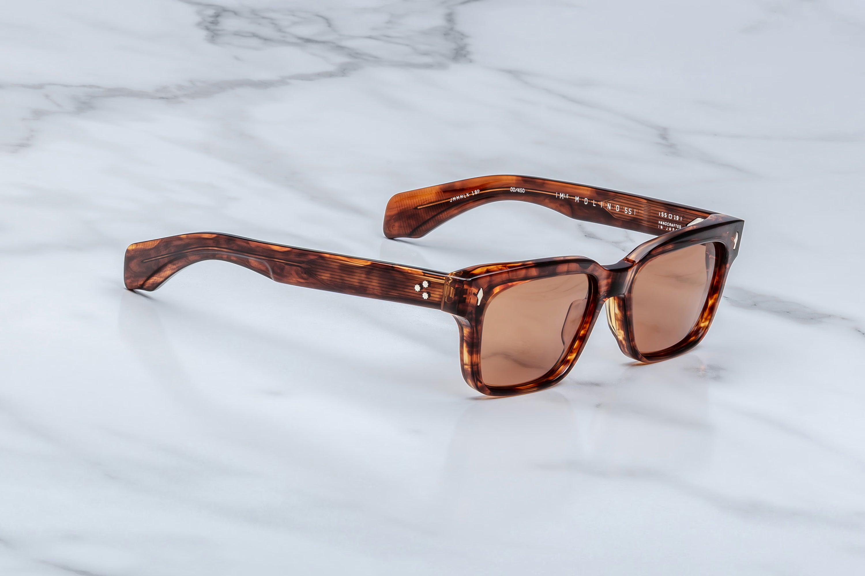 Brown sunglasses with tortoiseshell frame on a marble surface