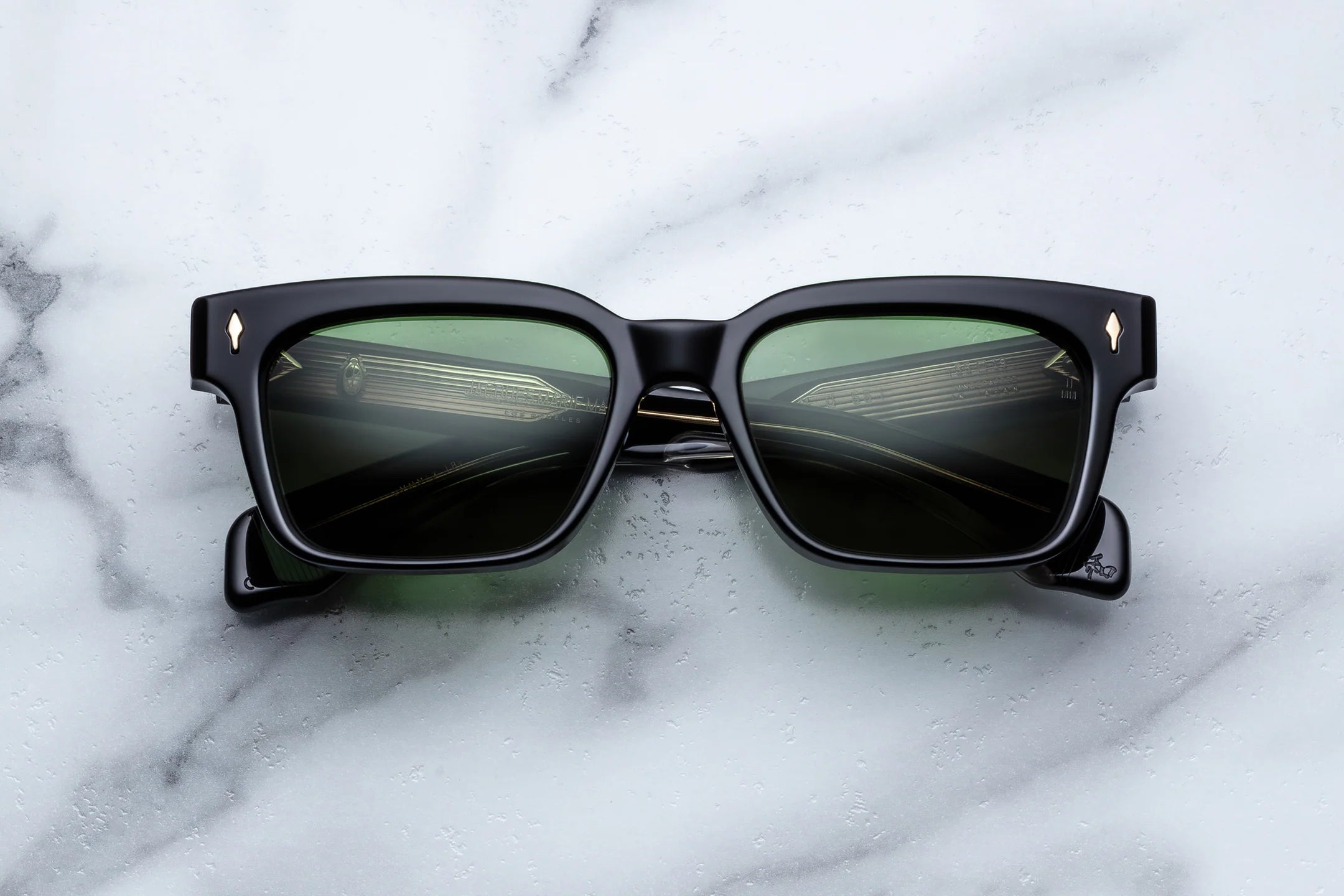 Black sunglasses with reflective lenses on a marble surface
