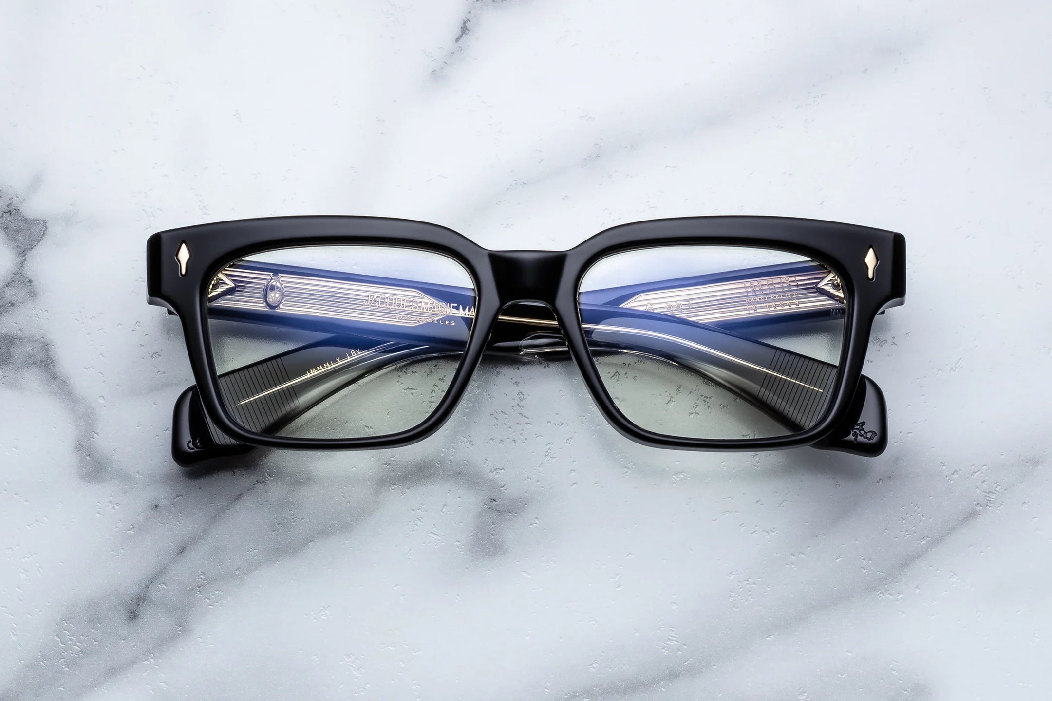 Black-framed glasses on a marble surface