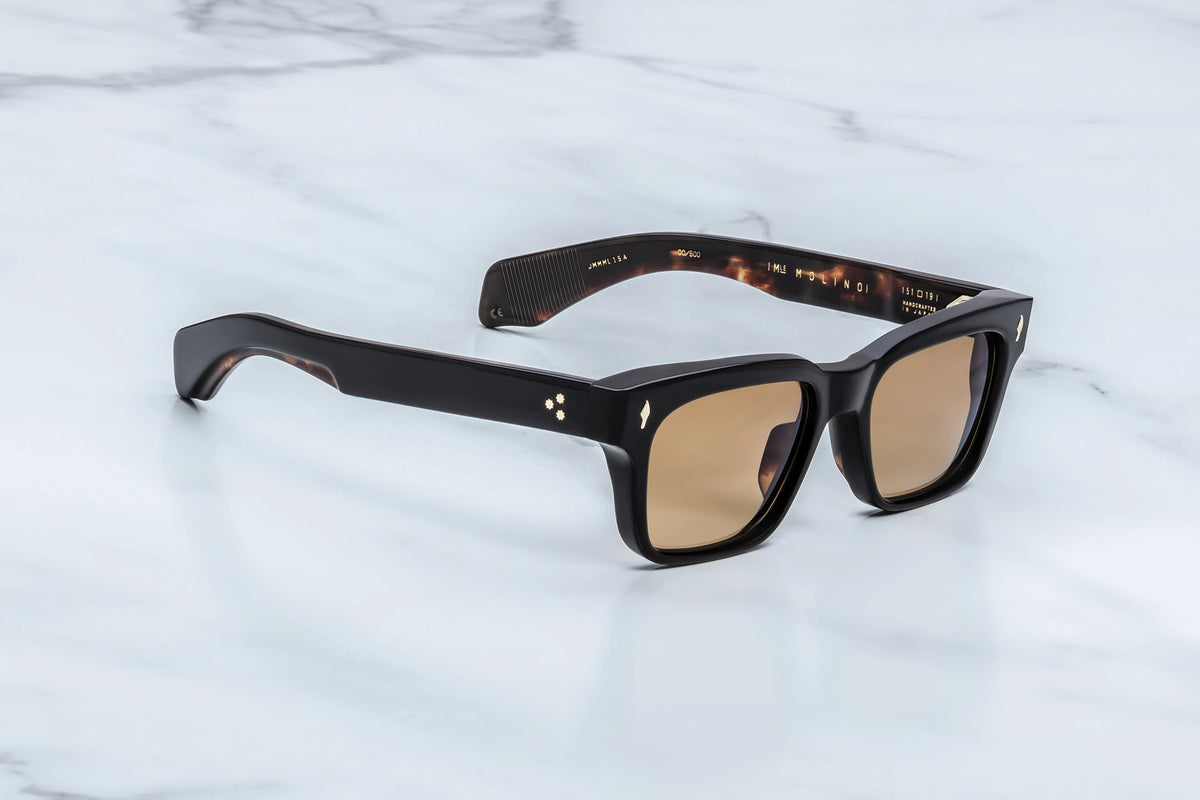 Jacques Marie Mage Molino rectangular sunglasses in black with amber lenses and gold pin detailing.