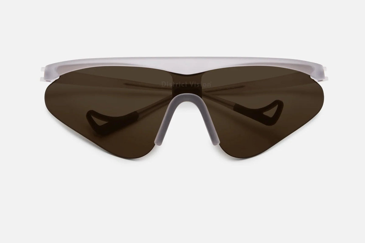 District Vision Momoka Pacer sunglasses by District Vision, featuring a single dark, oversized lens and a white TR90 frame, shown from the front against a plain white background.