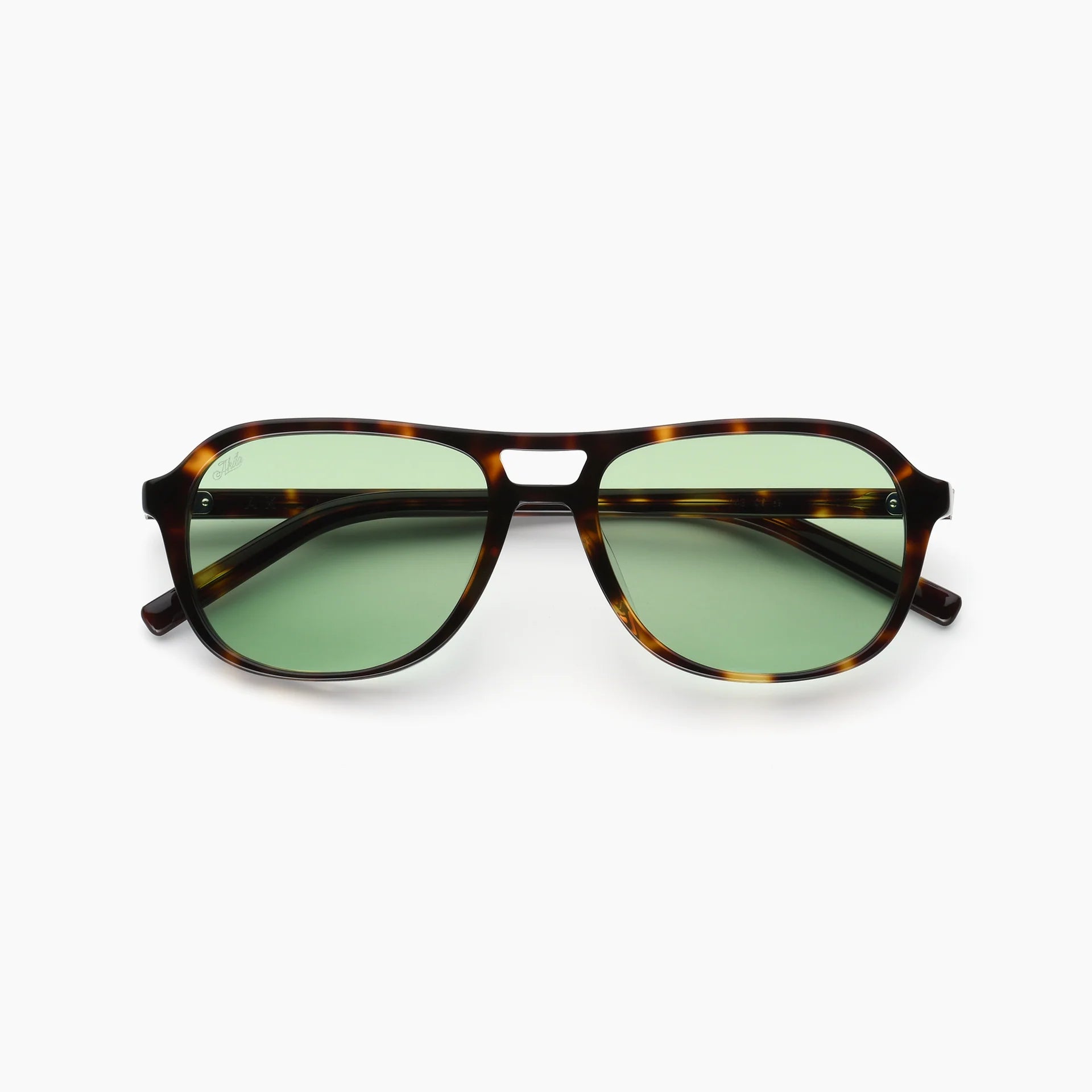 Sunglasses with tortoiseshell frame and green lenses on a white background
