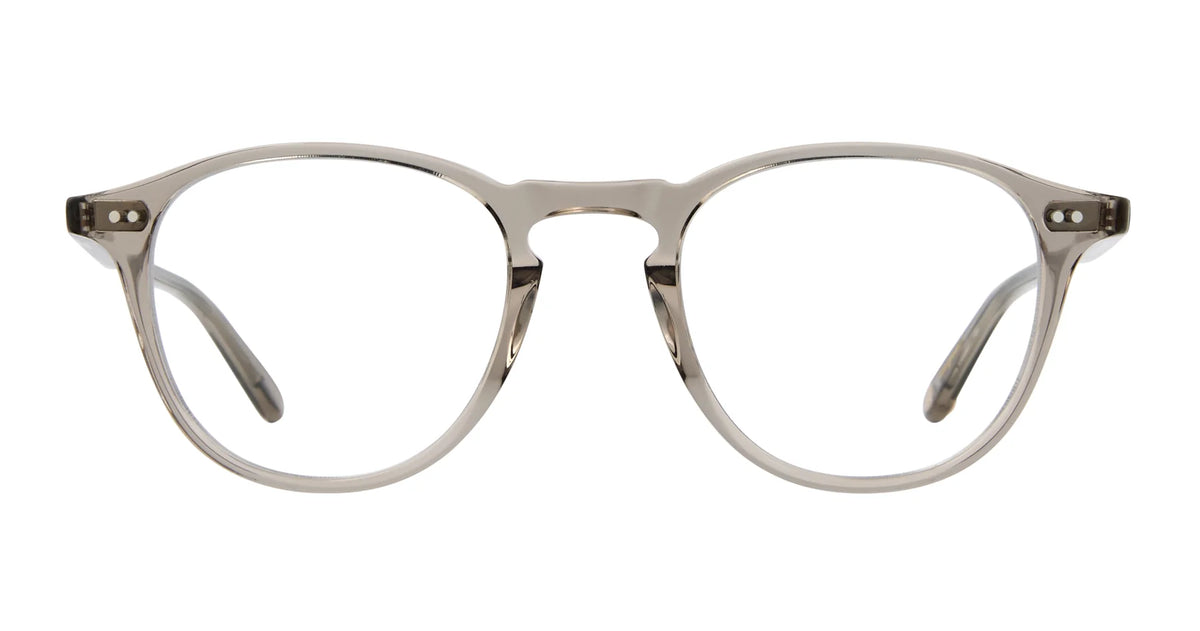 Garrett Leight Hampton 44 by Garrett Leight features clear round eyeglasses with a subtle grayish acetate optical frame, keyhole bridge, and metal rivet accents on the upper corners that evoke classic P3 eyeglasses, shown on a white background.