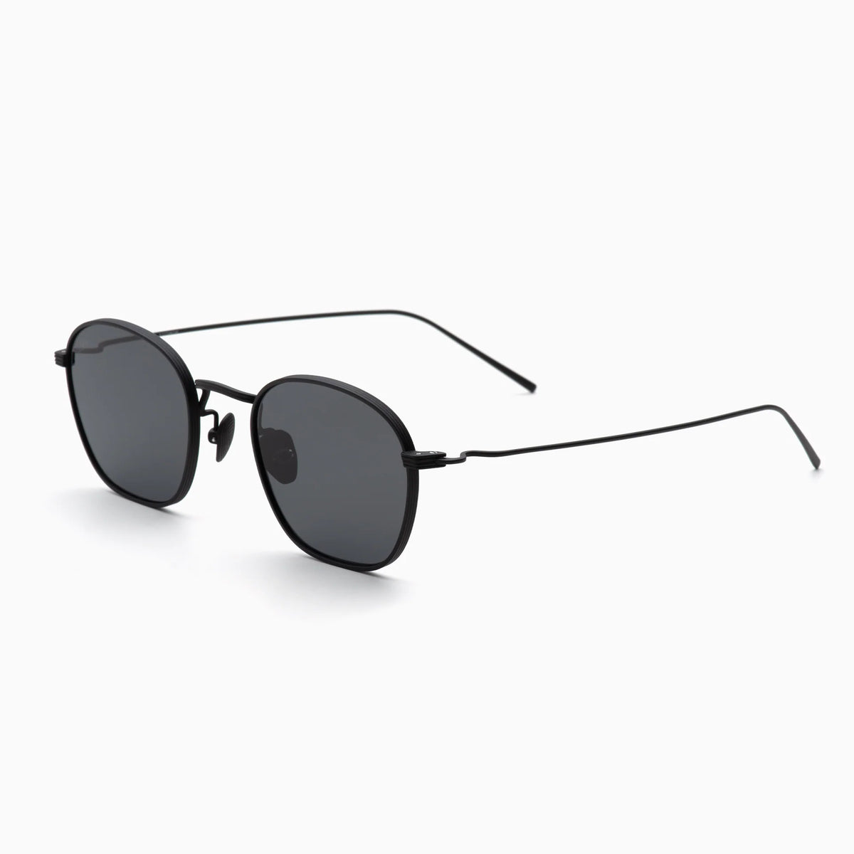 Black round sunglasses with thin, lightweight metal frames and dark tinted lenses, shown on a white background and angled slightly to the left—an elegant piece: the Akila Osiris from Akila.
