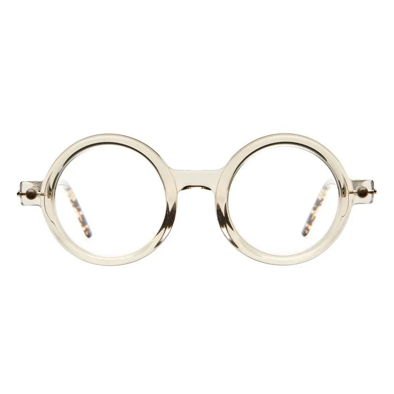 Kuboraum P1 designer eyewear with round, translucent beige frames and tortoiseshell-patterned temple tips.