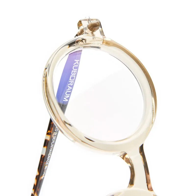 Translucent beige round Kuboraum P1 masks with text printed on the inner lens and temple arm.