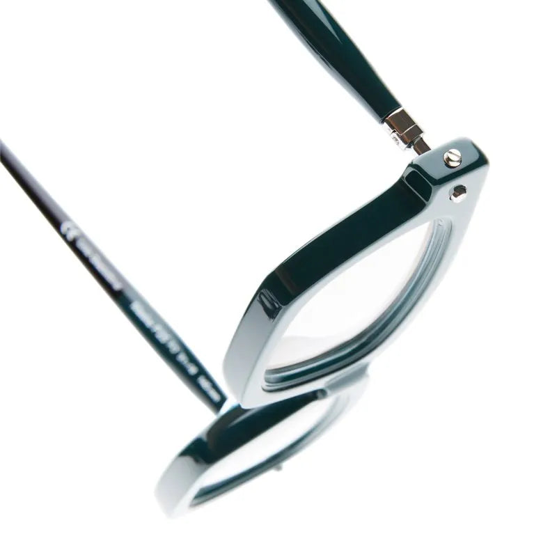 Close-up view of a pair of Kuboraum P25 black eyeglasses, displayed at an angle on a white background to emphasize the detailed frame and lens edges. Crafted by Kuboraum and inspired by Berlin Italy artistry, these masks exemplify exquisite handmade eyewear design.