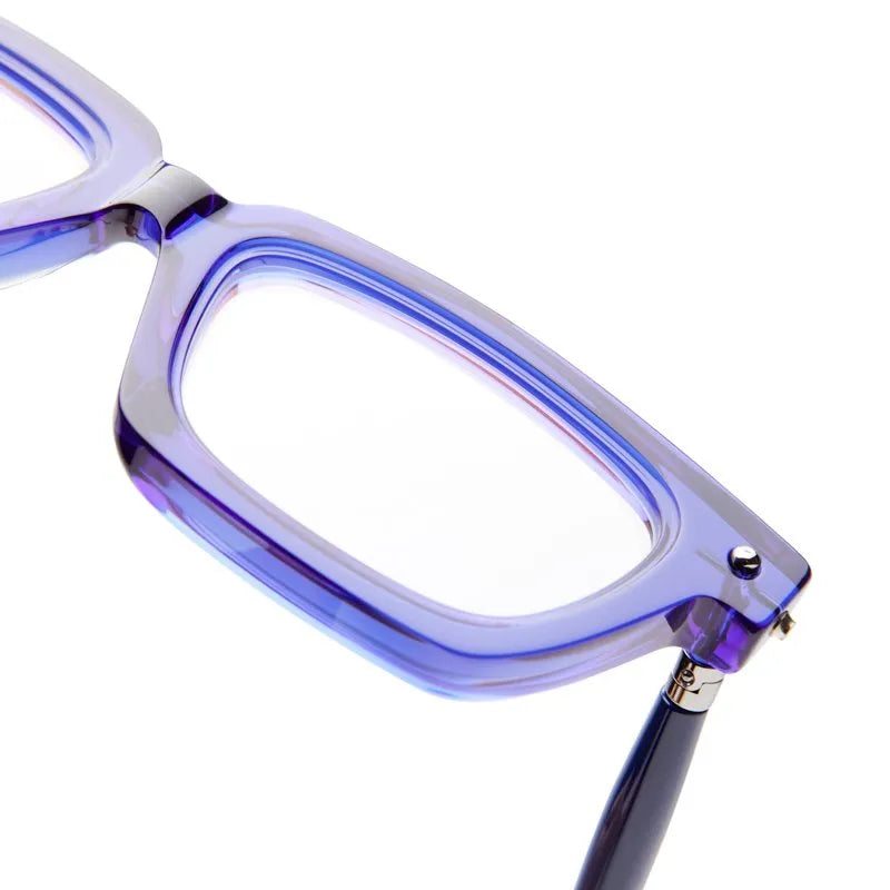 Close-up of the Kuboraum P25, a pair of translucent purple eyeglasses with thick, rectangular frames, focusing on the upper right front corner and part of the temple arm—an exquisite piece of designer eyewear by Kuboraum, handmade in Italy and evocative of the brand’s bold mask-inspired artistry.