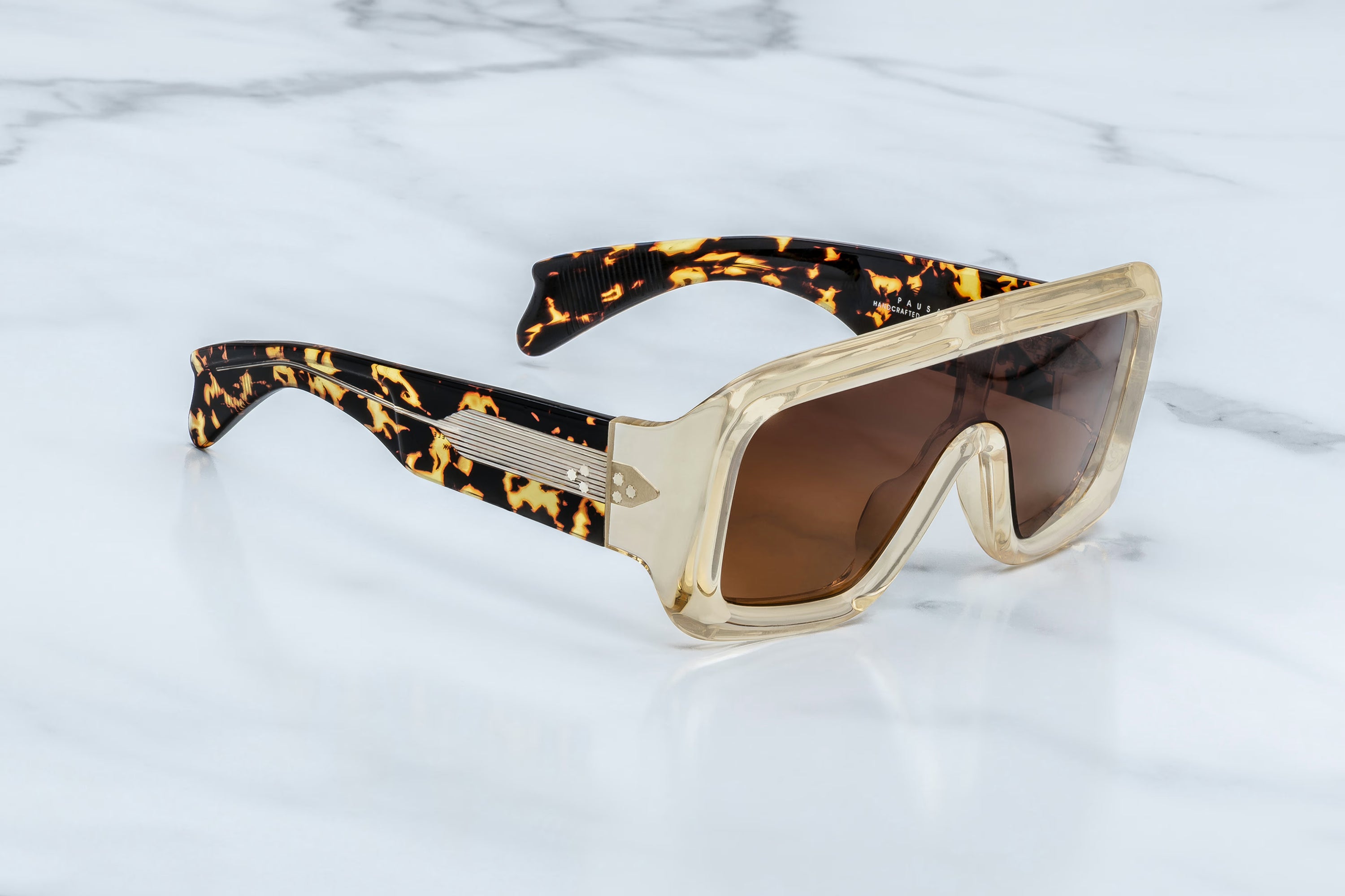 Sunglasses with tortoiseshell frame and brown lenses on a marble background