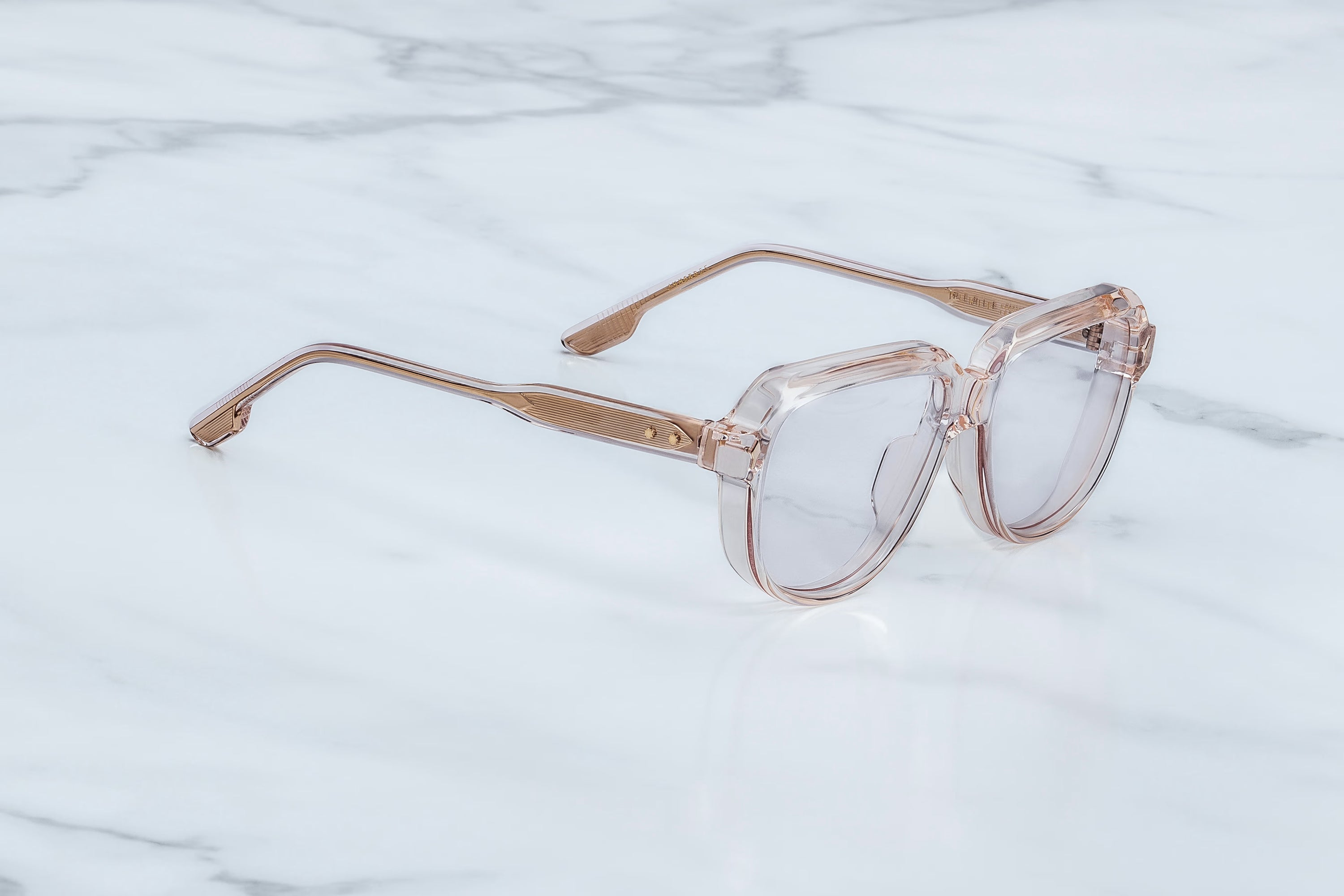 Clear glasses with gold frames on a marble surface