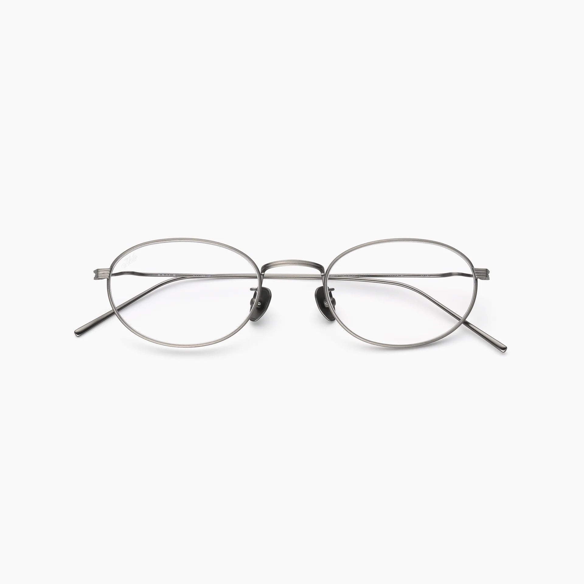 Silver oval optical glasses with thin metal rims, clear lenses, adjustable nose pads, slim temples, and a double bridge, shown front-facing on a white background.