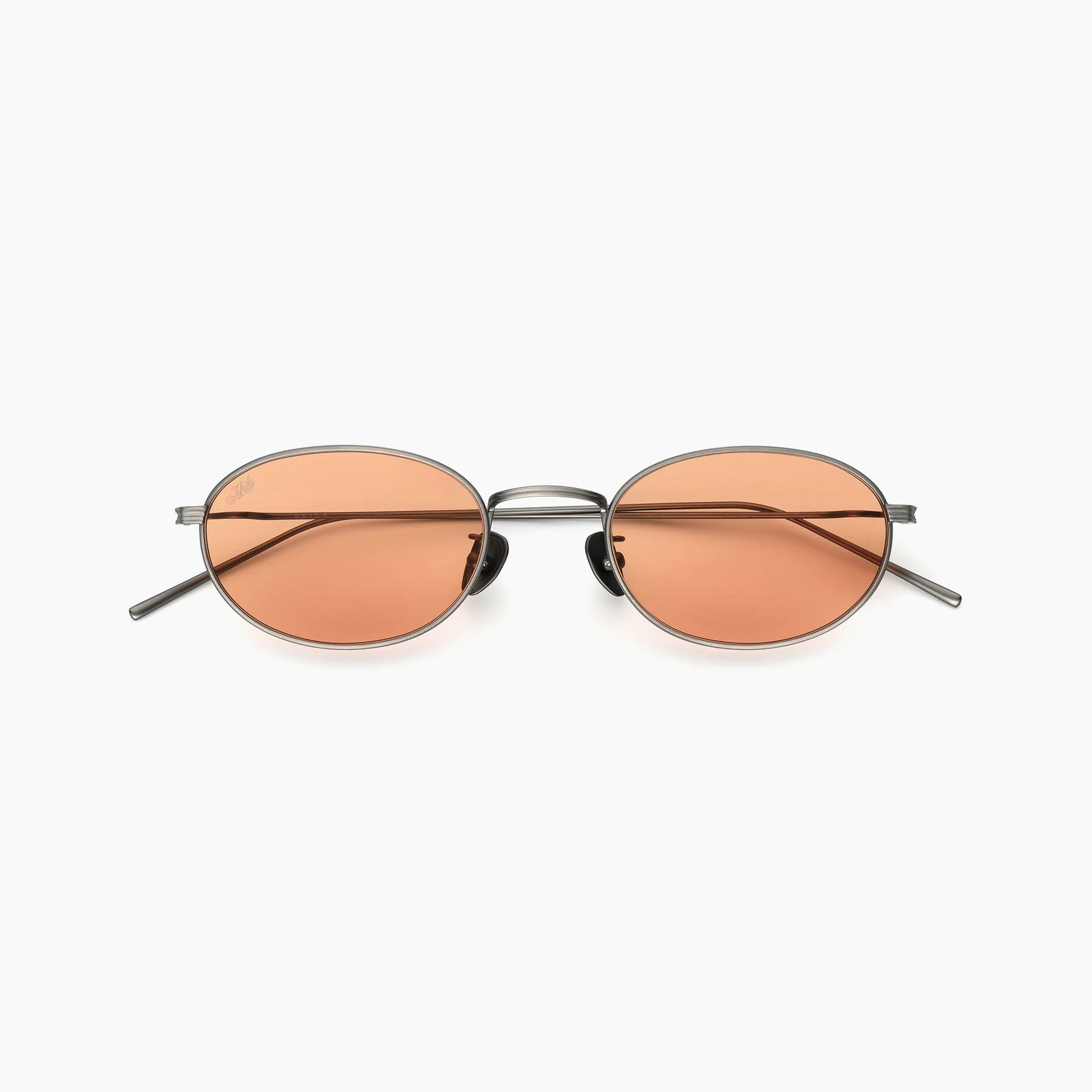 Oval metal-frame sunglasses with orange-tinted lenses, adjustable nose pads, slim temples, and a double bridge, shown front-facing on a white background.