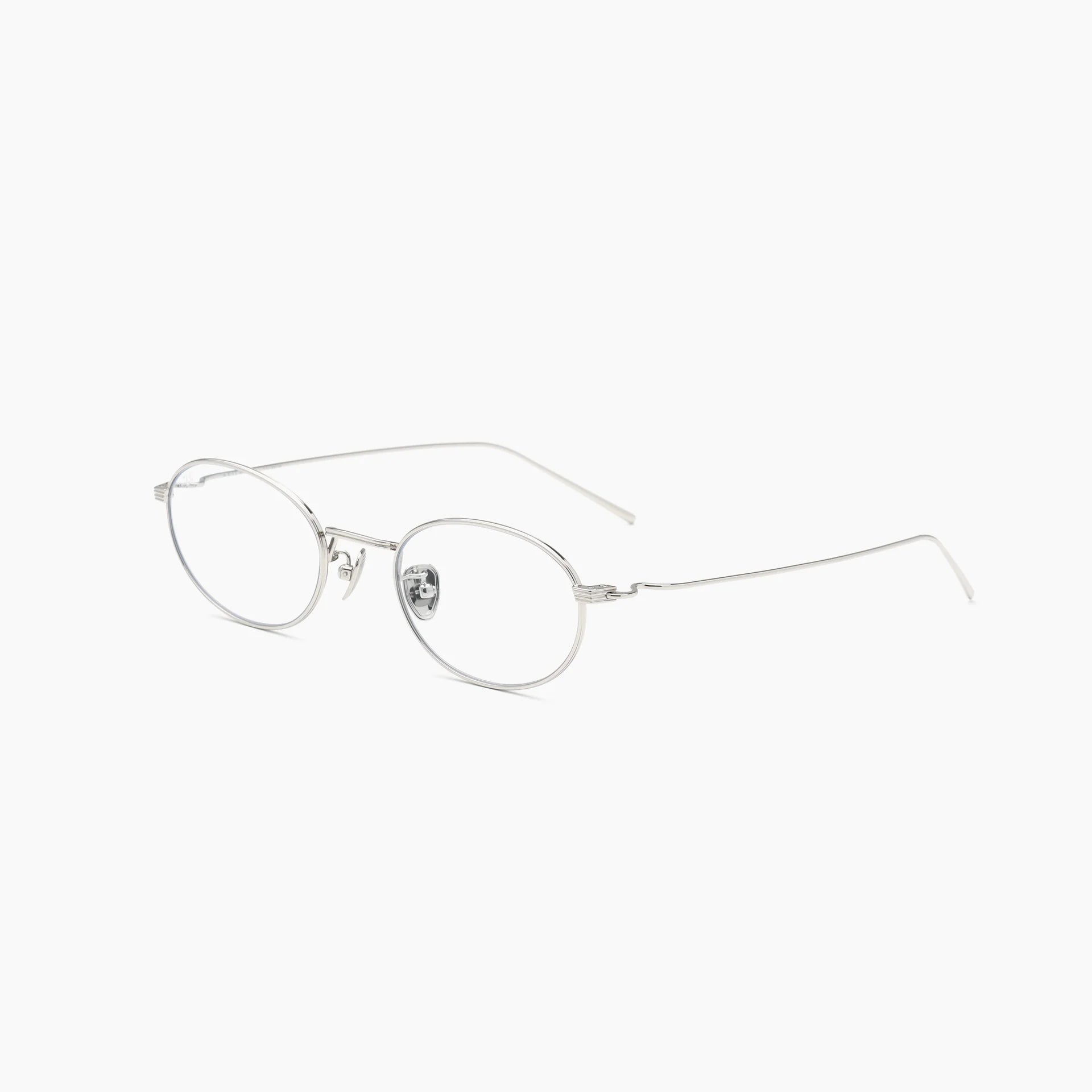 Silver oval optical glasses with thin metal rims, clear lenses, adjustable nose pads, and slim wire temples, shown at an angled side view on a white background.