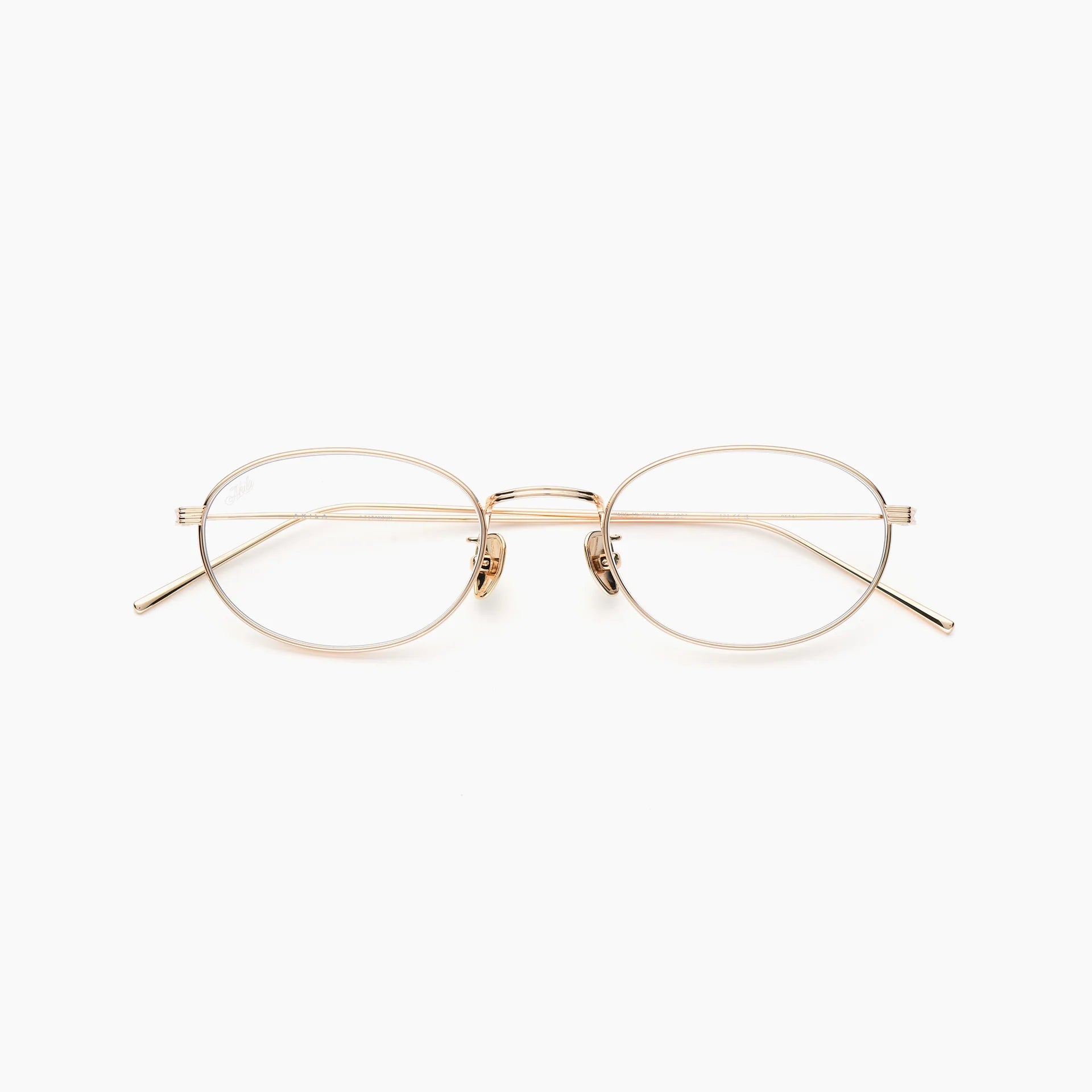 Gold oval optical glasses with thin metal rims, clear lenses, adjustable nose pads, slim temples, and a double bridge, shown front-facing on a white background.