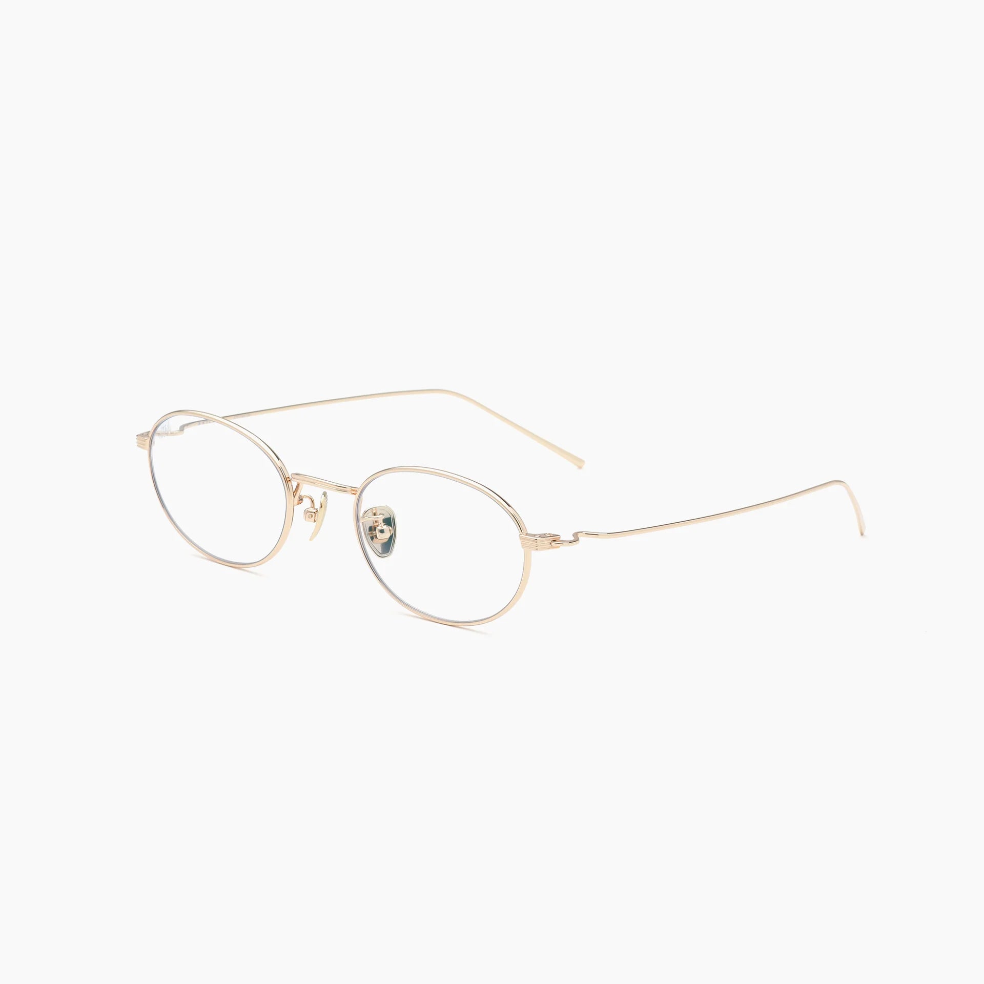 Gold oval optical glasses with thin metal rims, clear lenses, adjustable nose pads, and slim wire temples, shown at an angled side view on a white background.