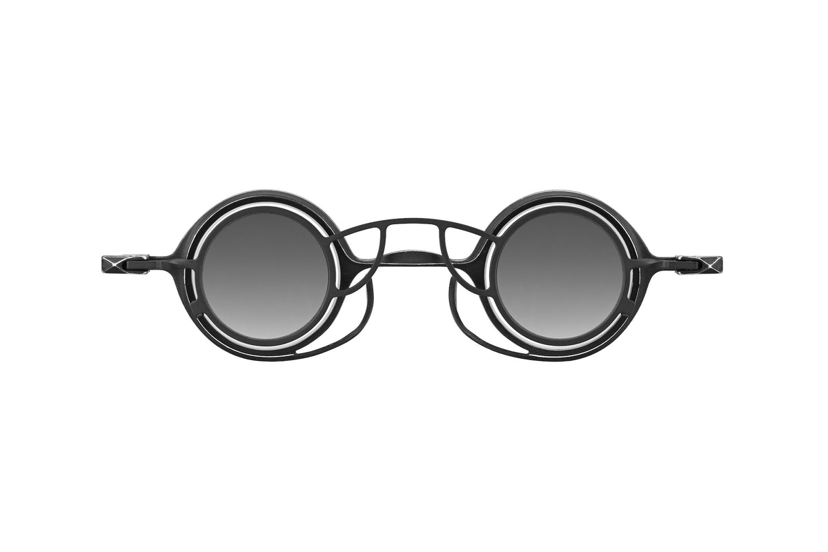 RIGARDS round sunglasses in black metal with grey gradient lenses, layered openwork rims, and an intricate geometric bridge, shown from the front.