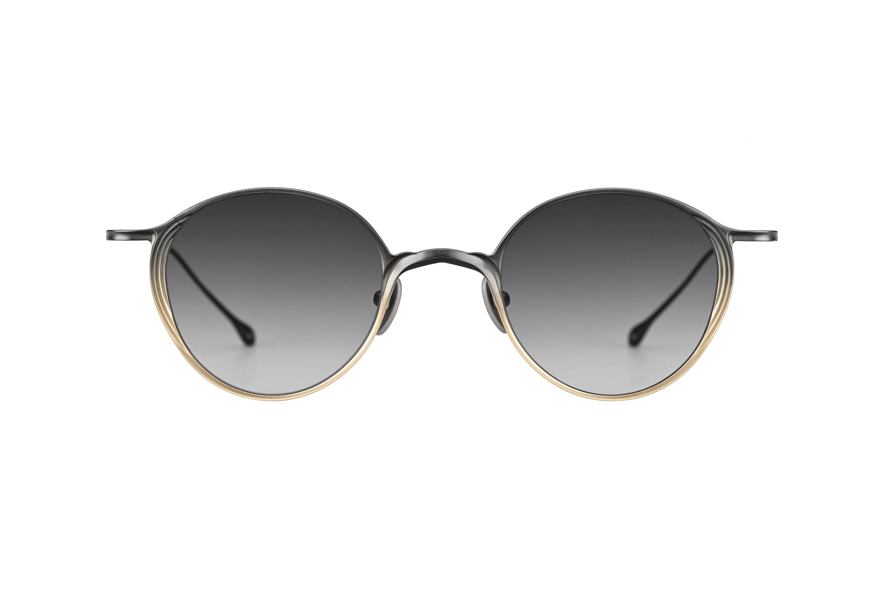 Oval sunglasses with a dark gray gradient lens, a thin silver metal frame, and a gold trim accent on the lower rim, shown against a plain white background.