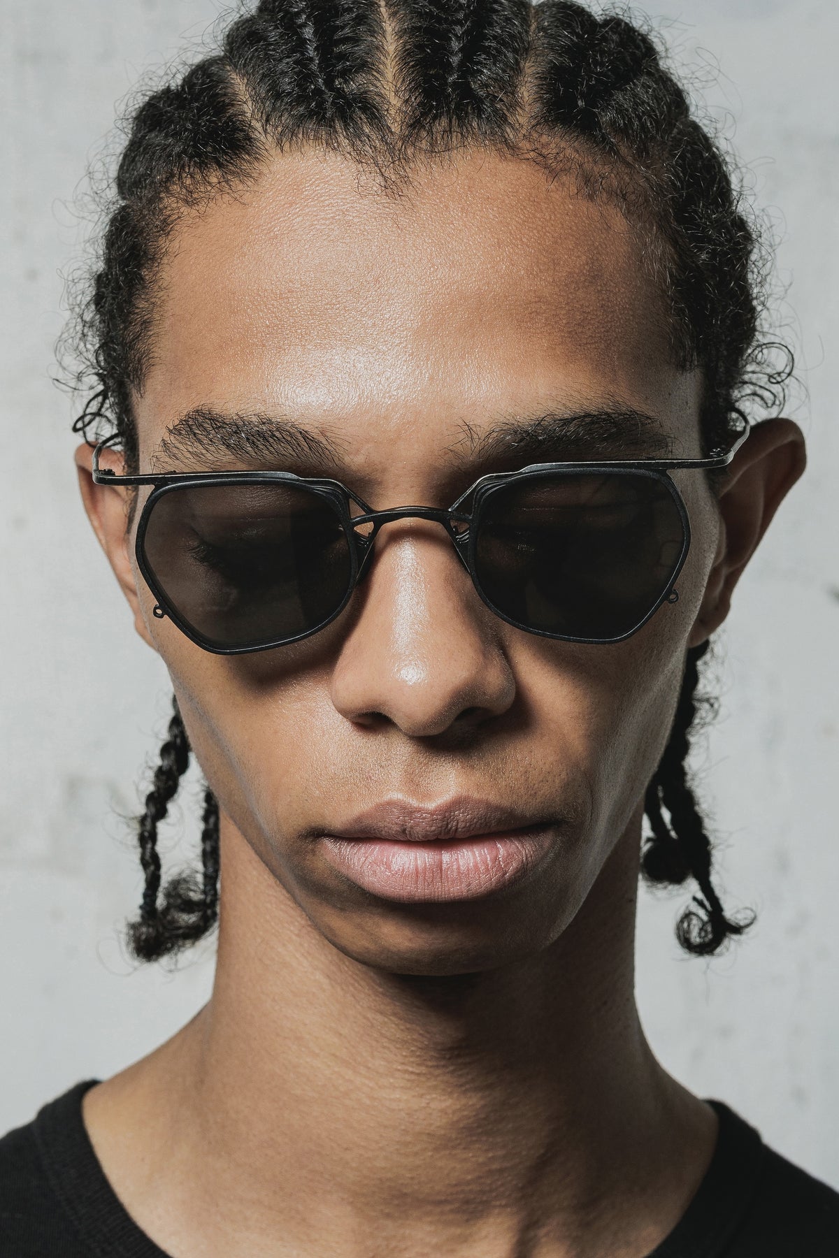 Model wearing black RIGARDS geometric sunglasses with dark lenses, photographed in a close-up portrait.