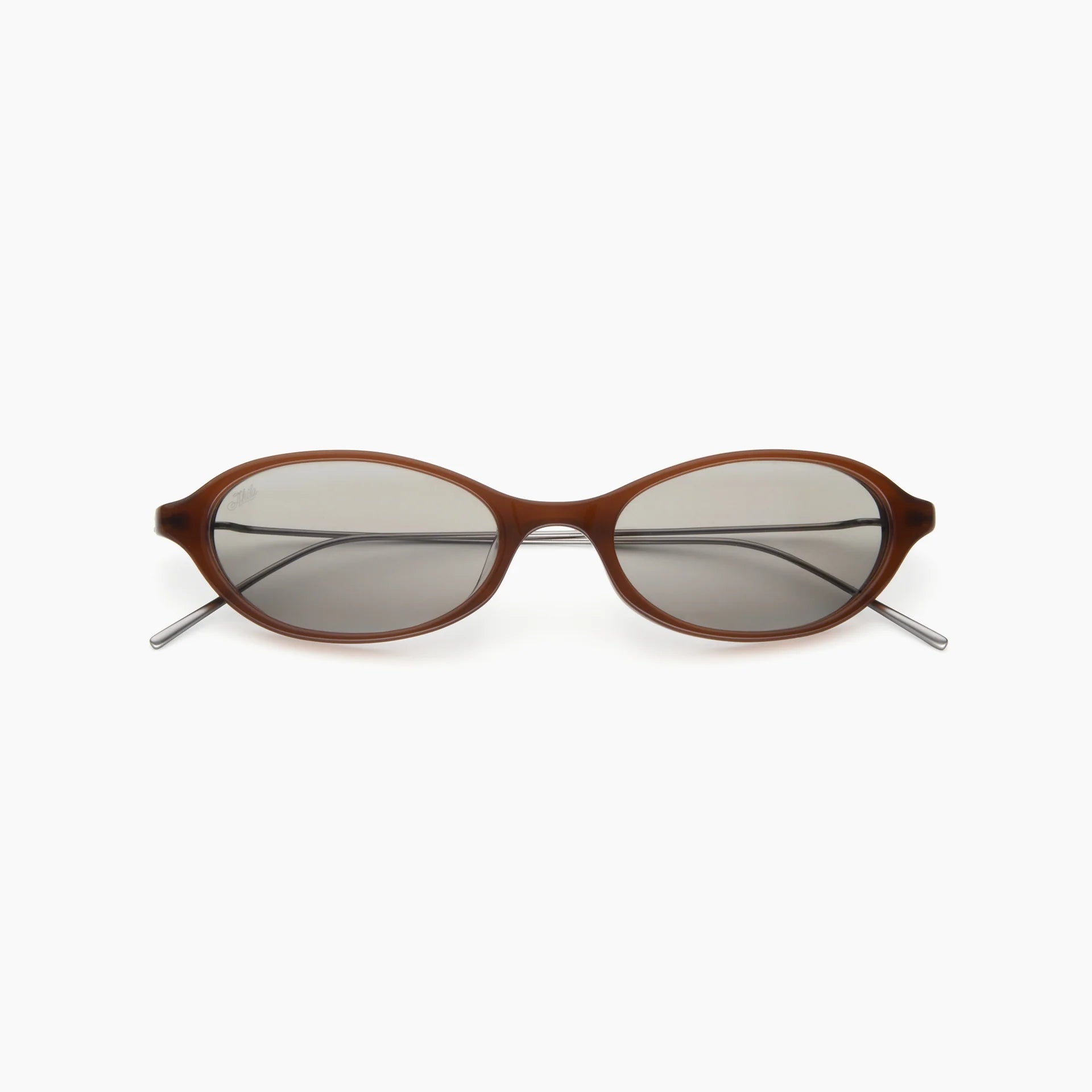 Brown oval sunglasses with light gray-tinted lenses and slim silver metal temples, shown front-facing on a white background.