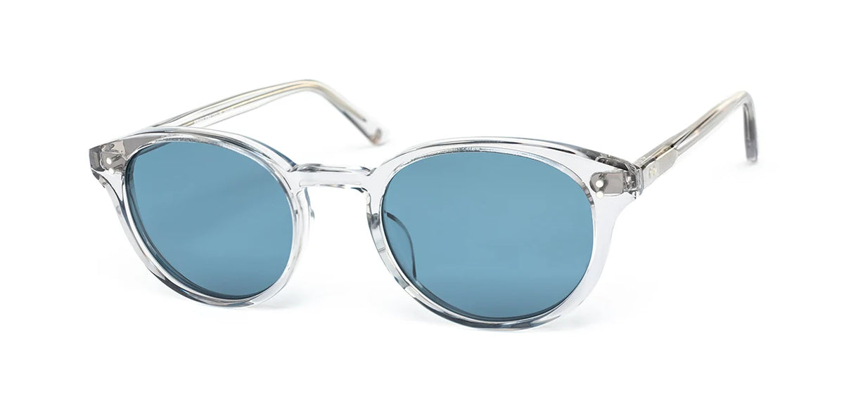 The SALT. Spencer sunglasses by SALT. feature clear round frames crafted from premium Japanese acetate, paired with blue-tinted lenses and displayed at an angle against a white background.